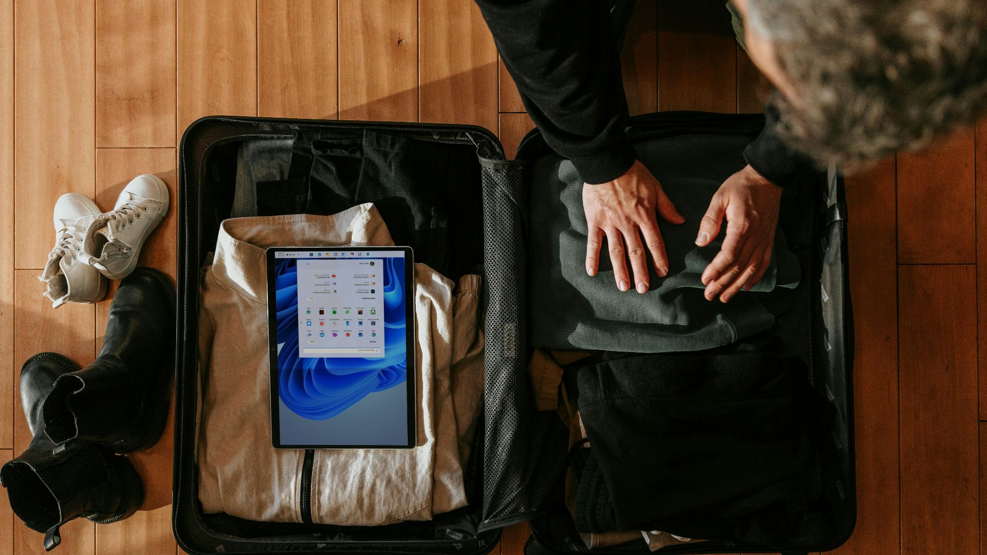 an overhead view of a person packing a suitcase