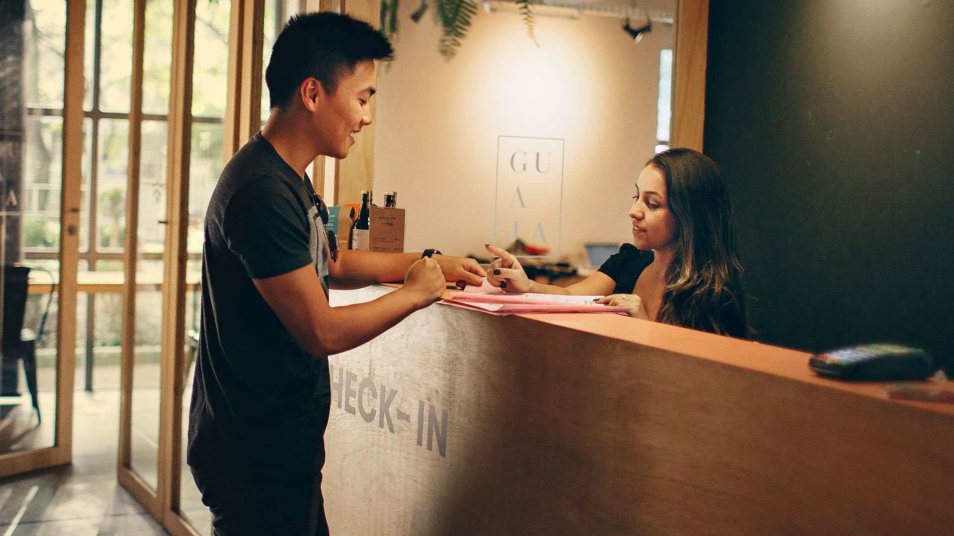 A customer checks in at a hotel reception desk in Belo Horizonte, Brazil.