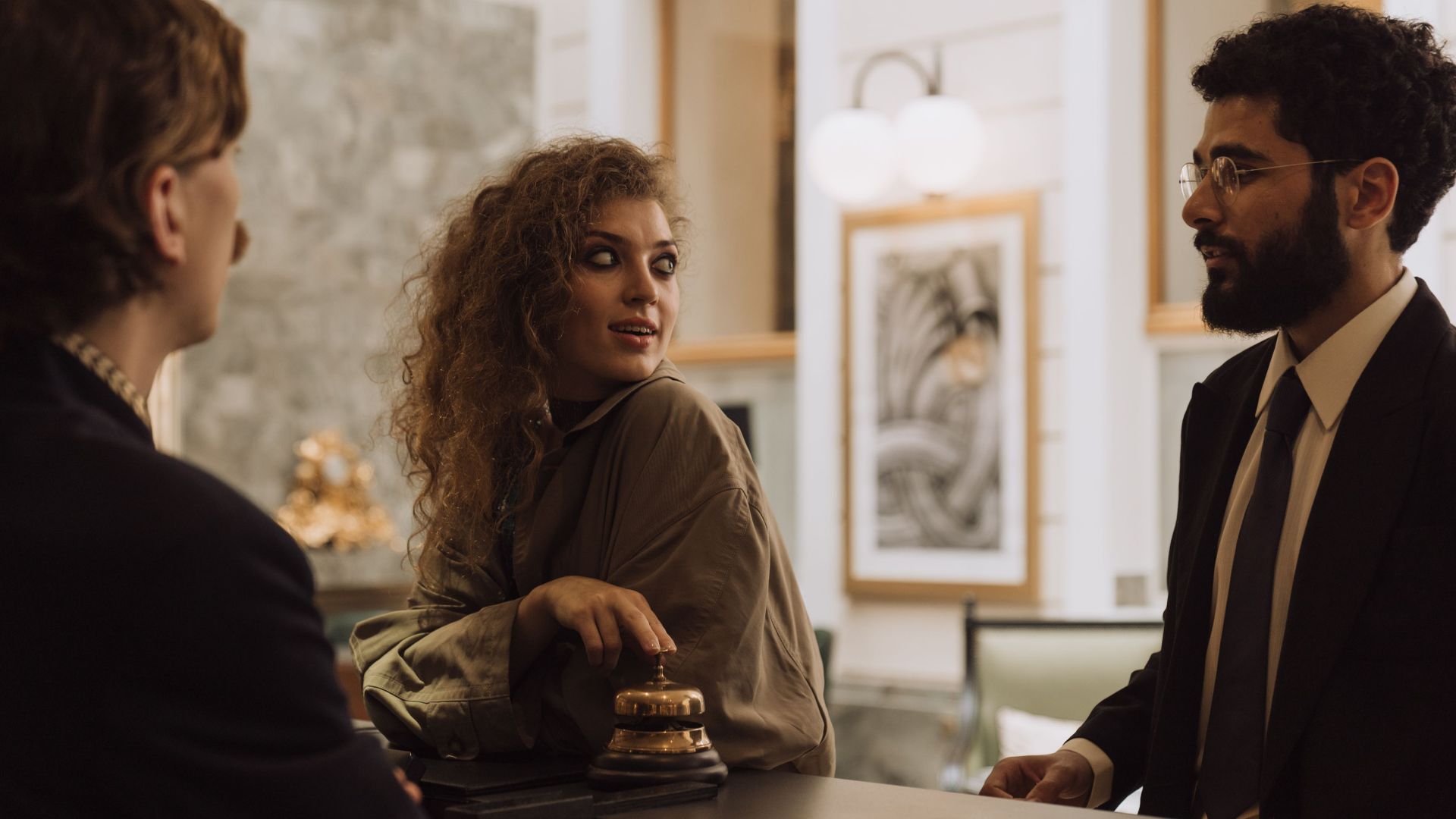 Guests interacting at a luxurious hotel reception desk, emphasizing hospitality and service.