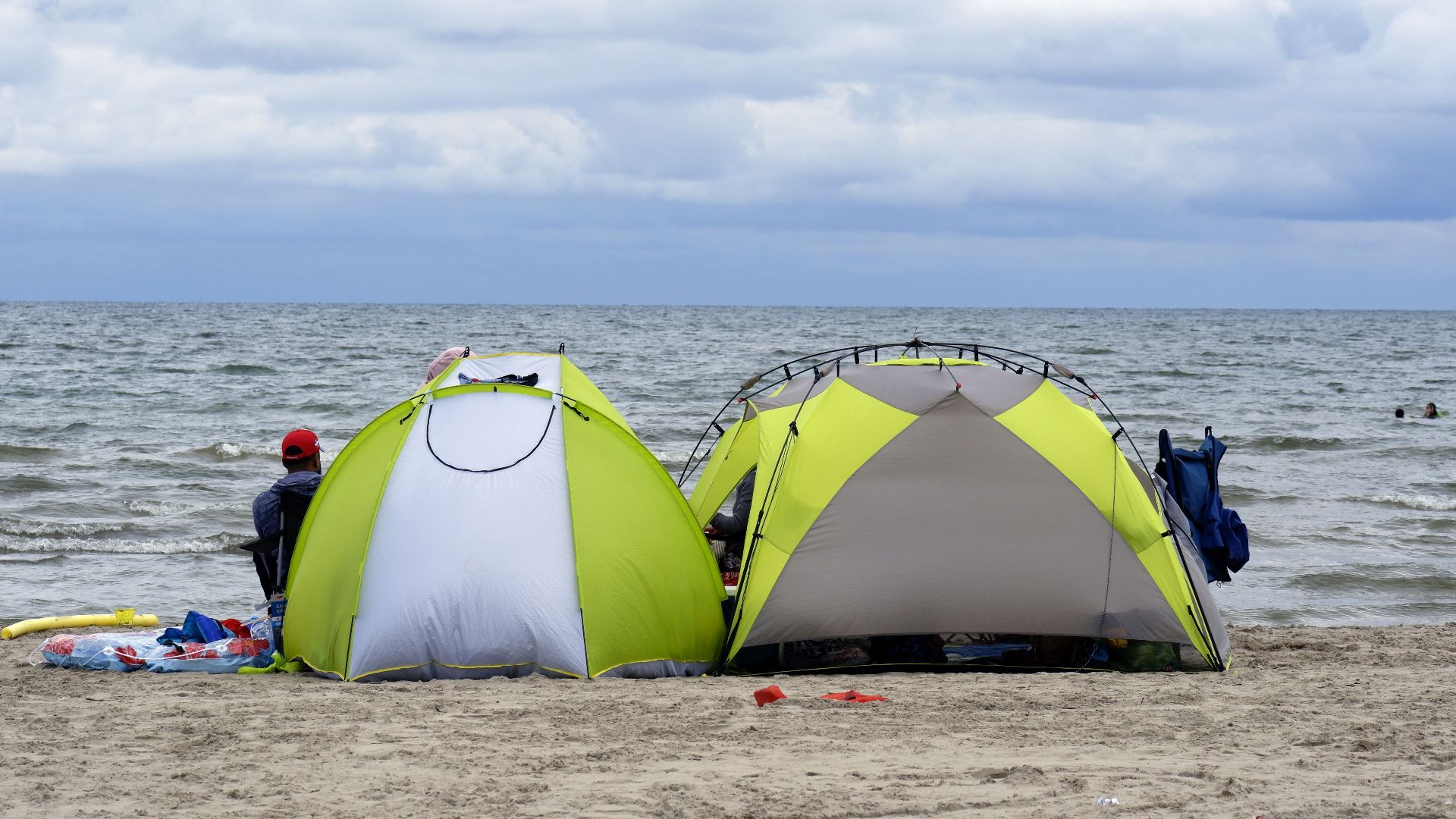 Relaxing beach scene with tents by the sea under a cloudy sky, perfect for a serene vacation.