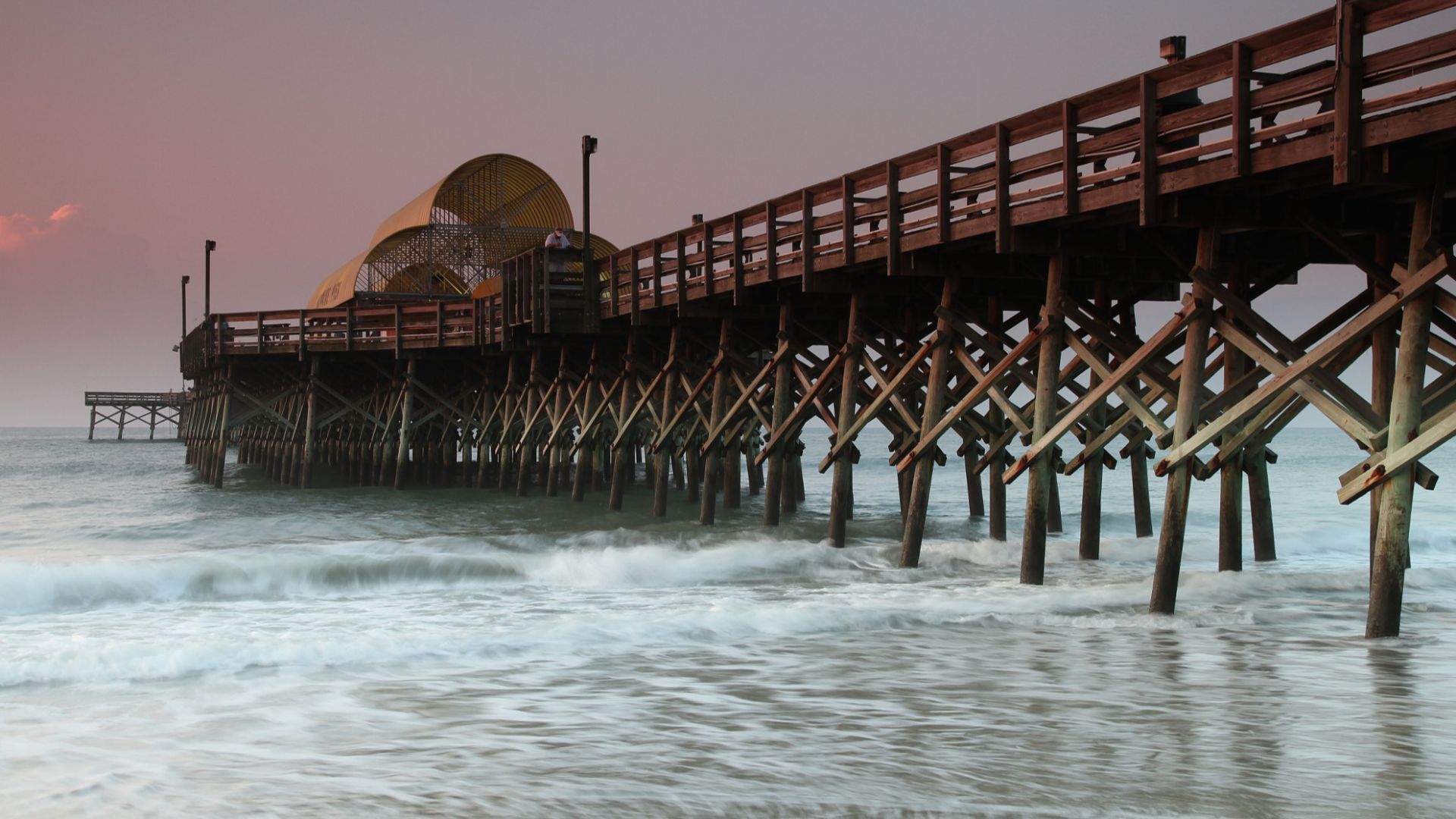 500px provided description: Apache Pier at Myrtle Beach at sunrise; 3/10 sec exposure to slightly blur the waves and fisherman; taken back in 2010. Great place to explore! [#Dawn ,#Myrtle Beach Apache Pier ,#Fishing from pier]