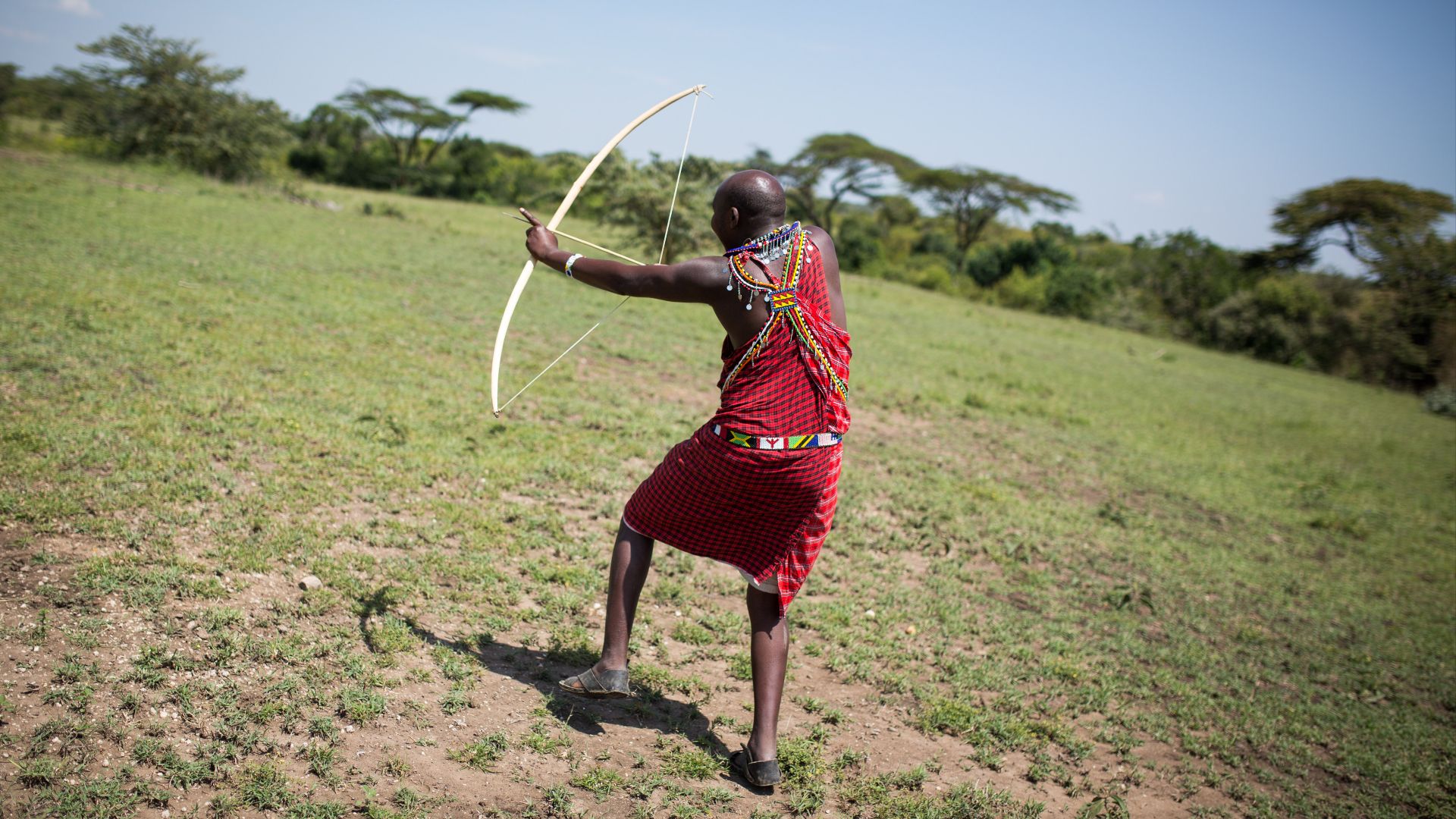 KENYA, Ol Kinyei, Maasai Mara: In a photograph taken by Make It Kenya 15 June 2015, a Maasai guide shoots a traditional hunting bow and arrow during a walking safari with Phil Edwards, a repeat, yearly vistor to Porini Mara Camp in the Ol Kinyei Conservan