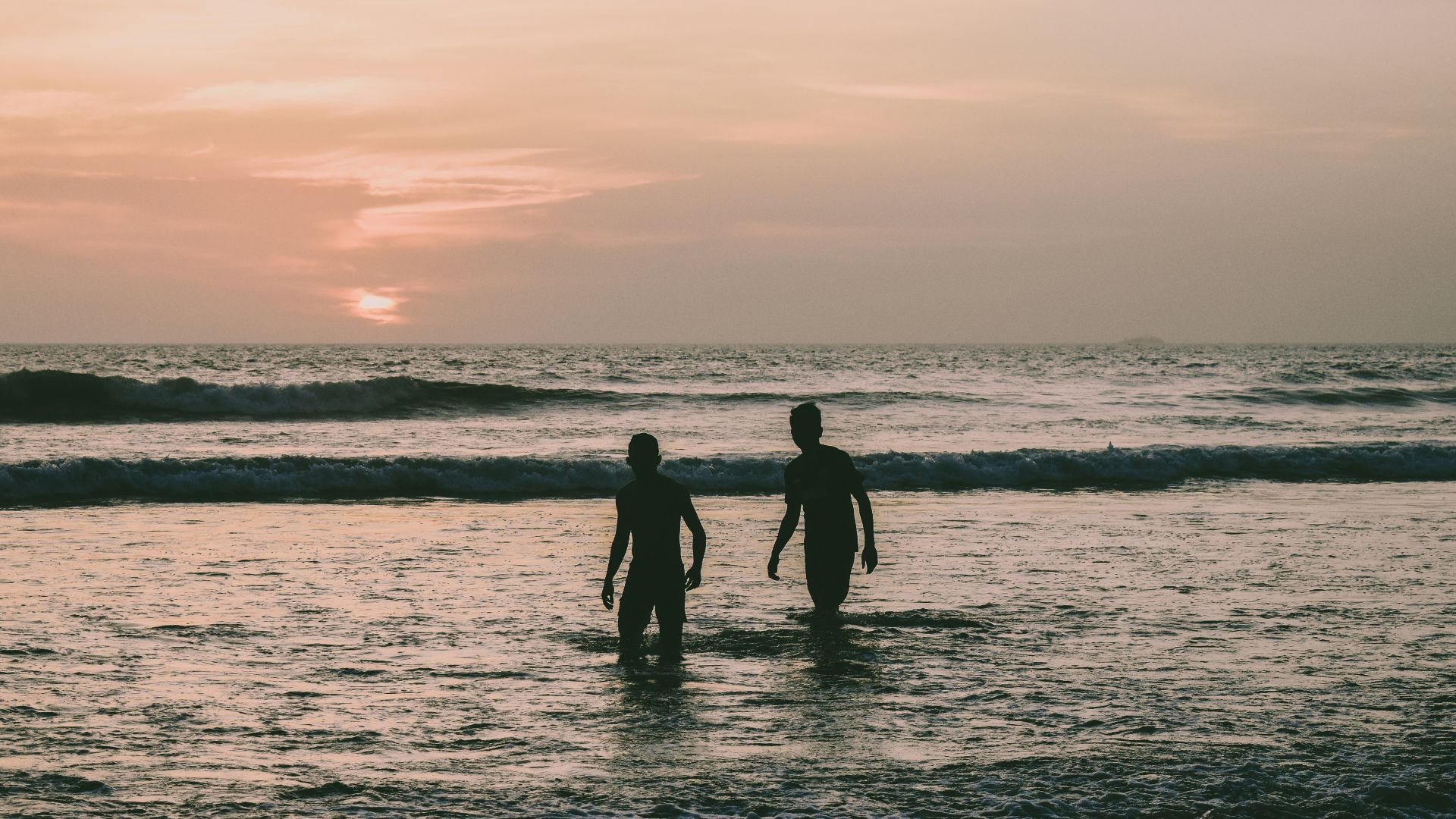 a couple of people standing on top of a body of water