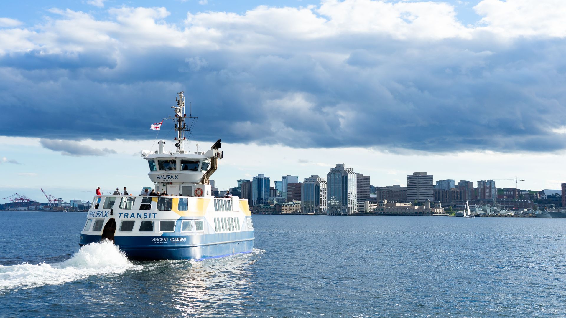 Halifax Transit ferry crossing the harbour with the downtown skyline in the background on a clear day.