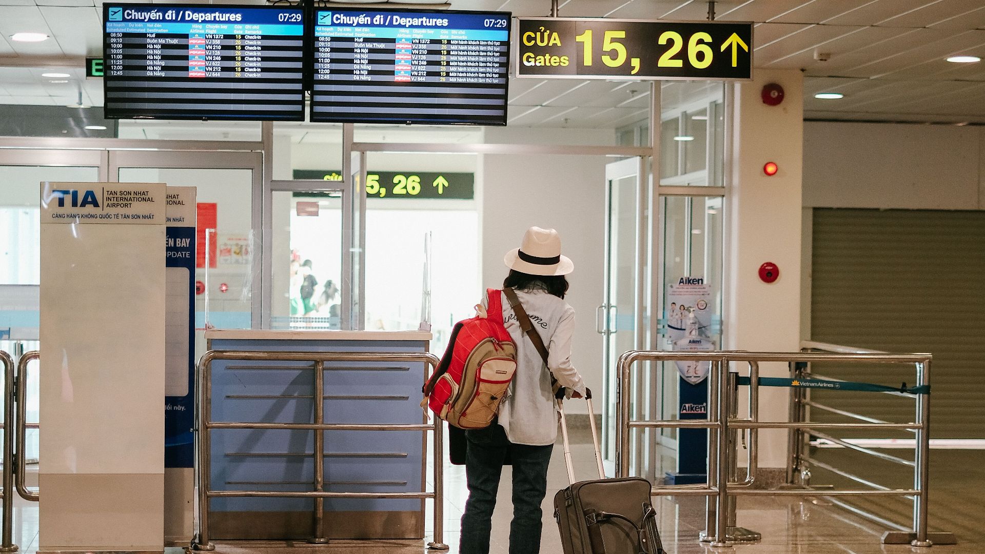 Woman with luggage exploring airport terminal. Solo travel and future adventures.