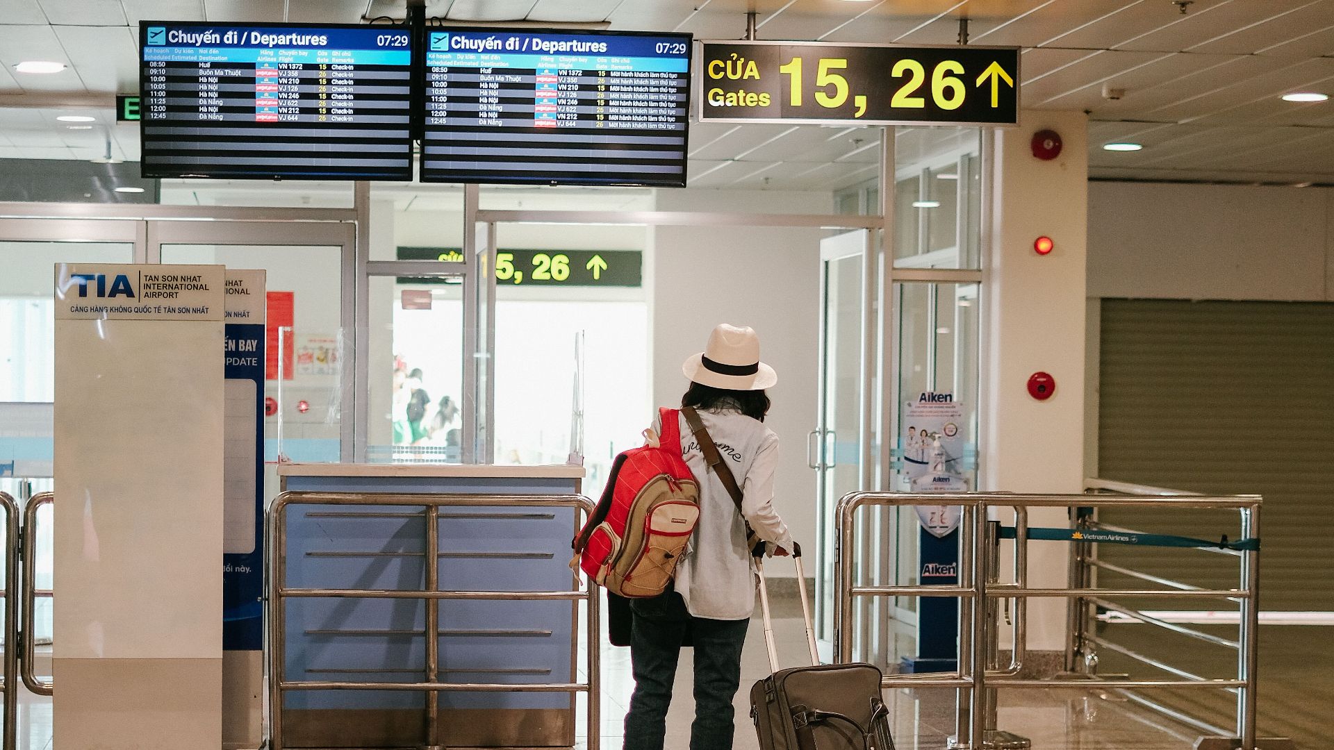 Woman with luggage exploring airport terminal. Solo travel and future adventures.