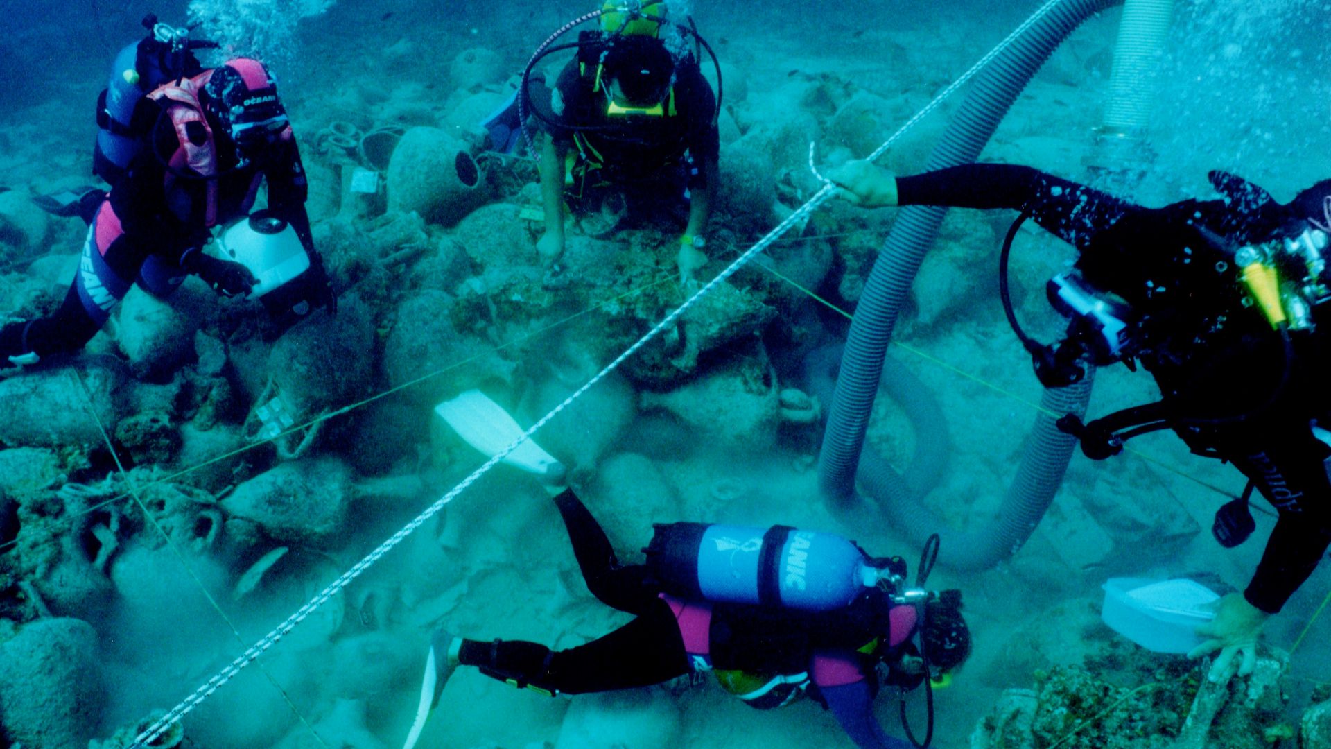 Diving archaeologists excavating the Alonnisos shipwreck in fall 2000, trench Θ3. The 2x2 m rope grid and airlift are visible.