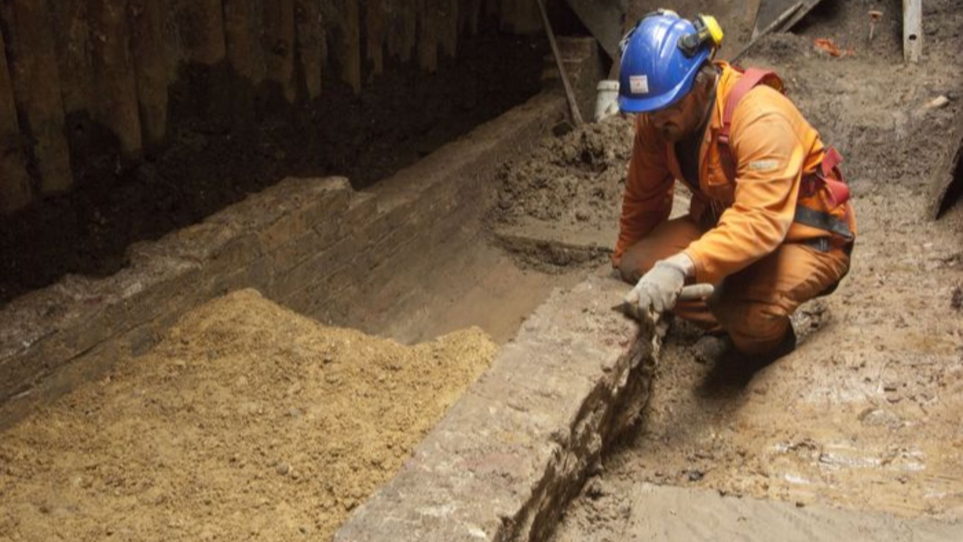 Archaeologist excavating a sewer at Liverpool Street Worksite, Liverpool Street (Crossrail XSM10)
