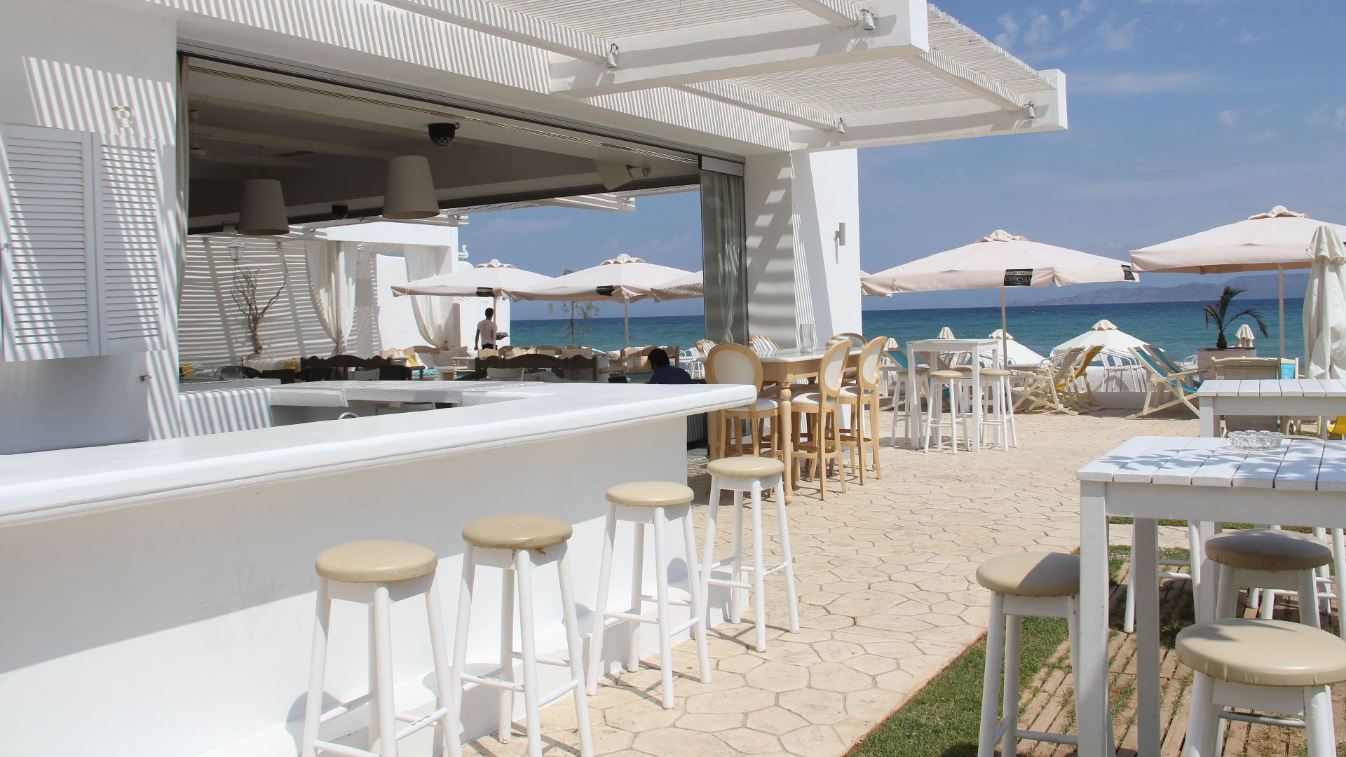 Elegant outdoor bar and restaurant by the ocean, perfect for a luxury vacation.
