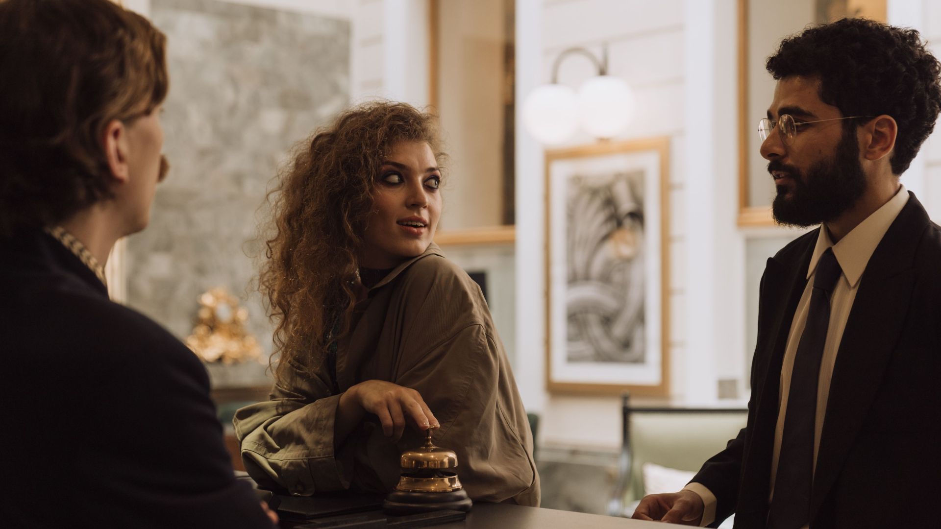 Guests interacting at a luxurious hotel reception desk, emphasizing hospitality and service.