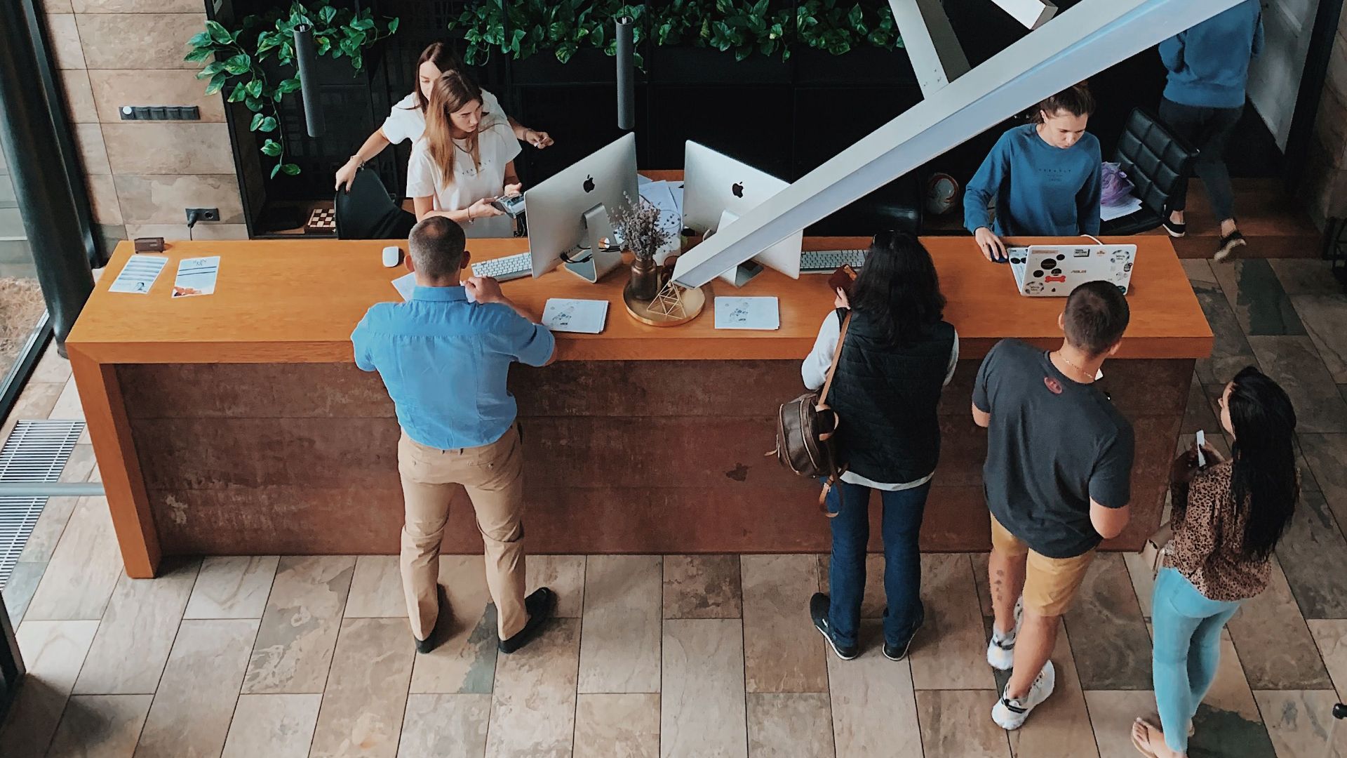 Aerial view of a modern hotel reception with people interacting at the desk in Sosnivka, Ukraine.
