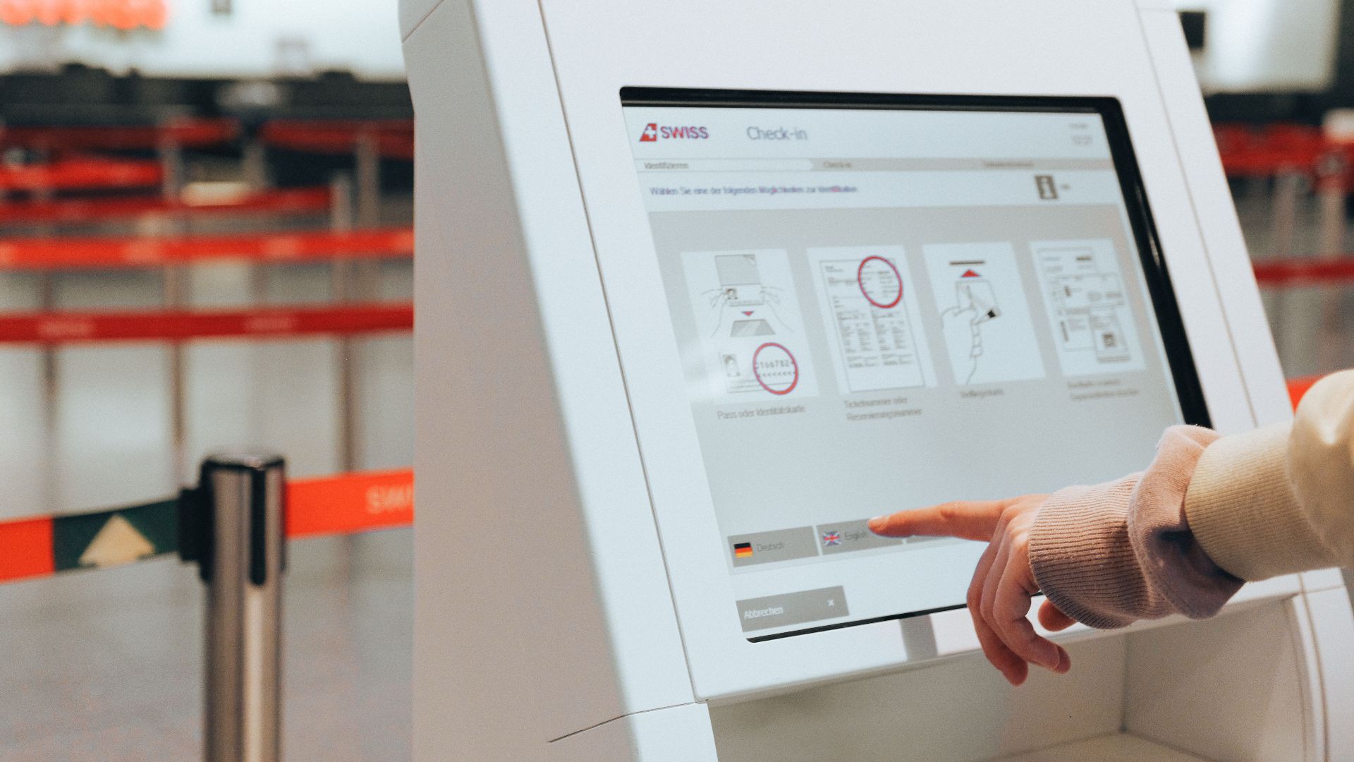 Passenger using self-service check-in kiosk at airport for convenient travel experience.