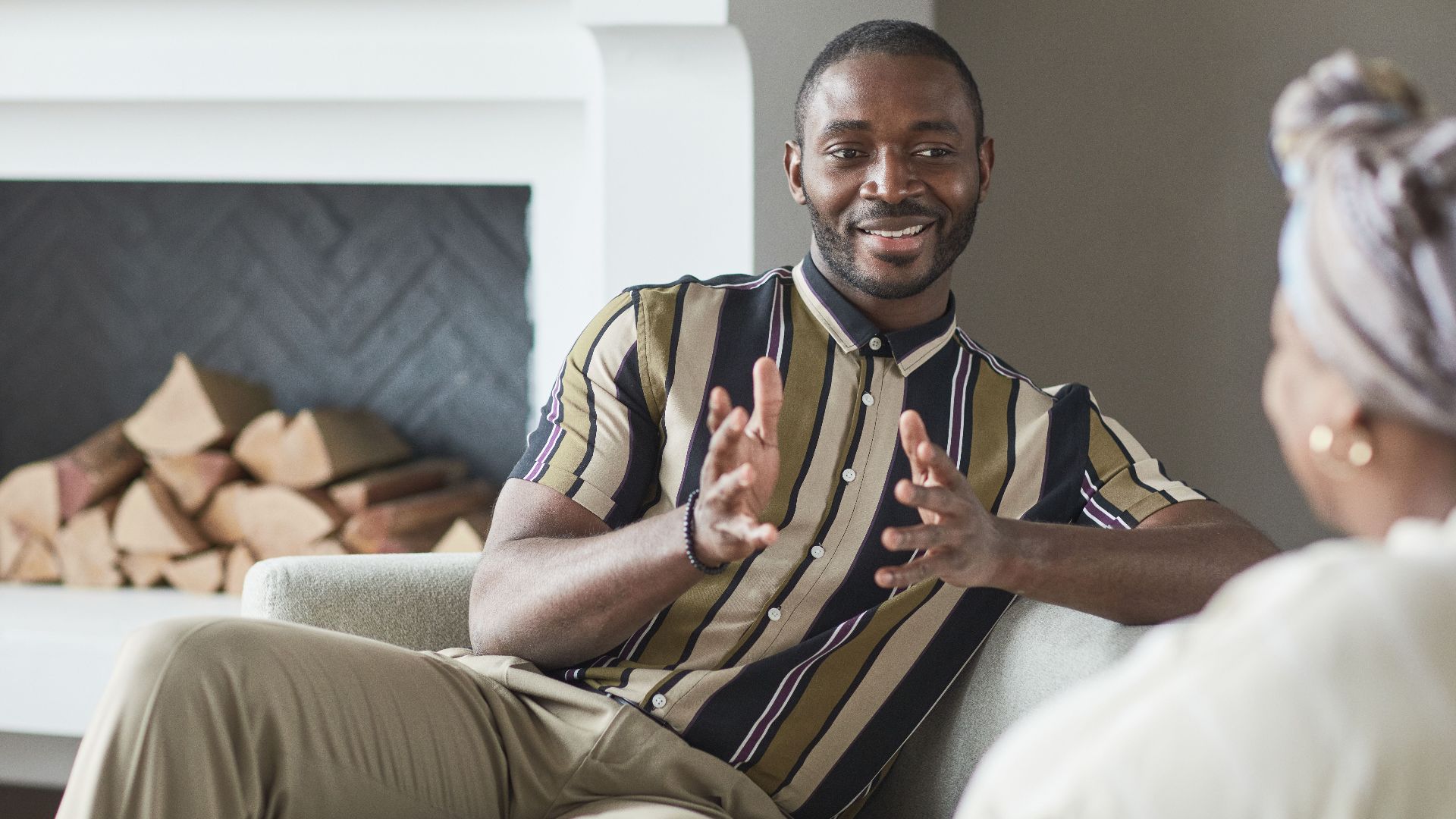 Two adults enjoying a friendly conversation in a cozy modern living room setting.