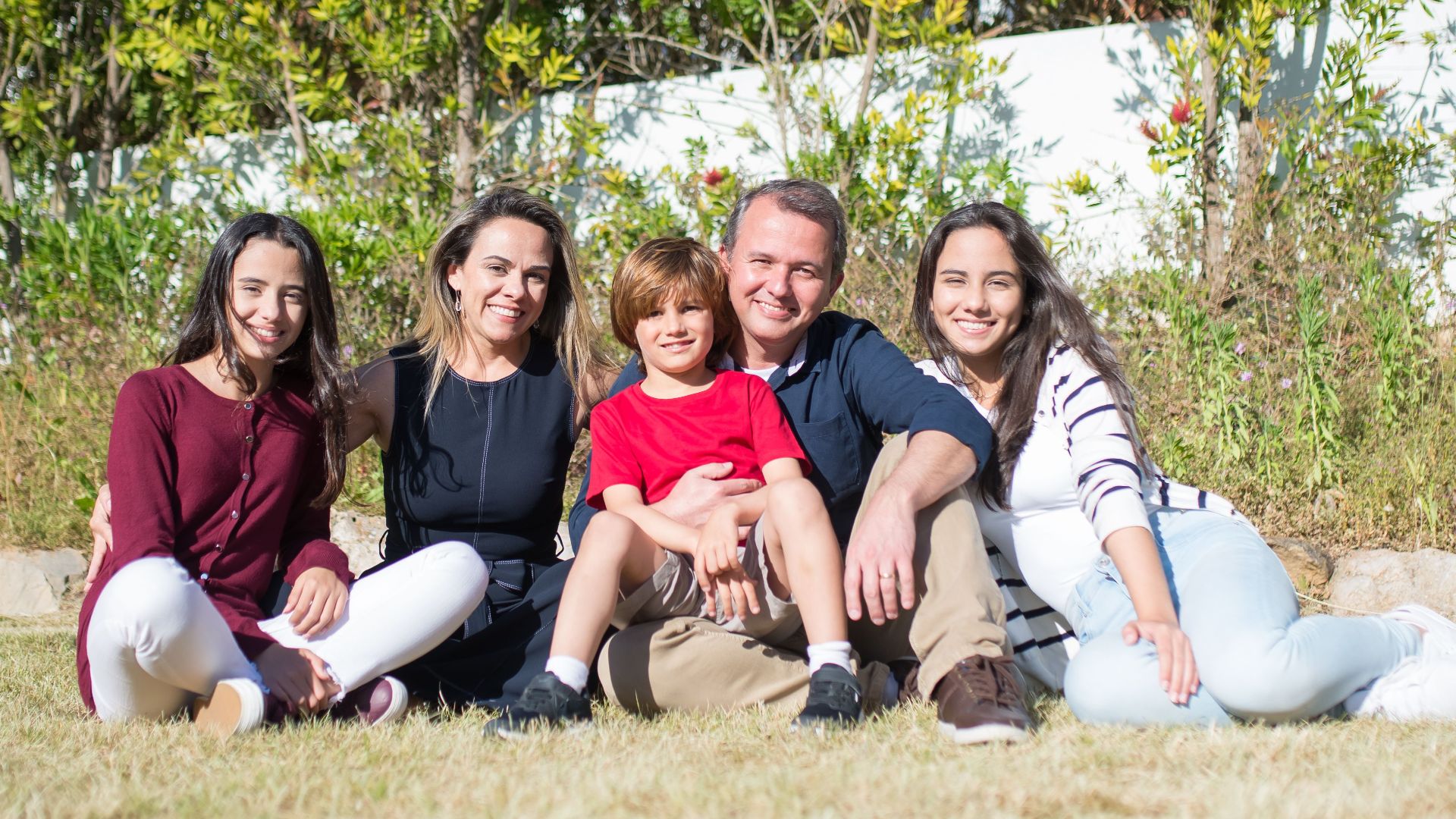 A cheerful family enjoying quality time together outside on a sunny day in Portugal.
