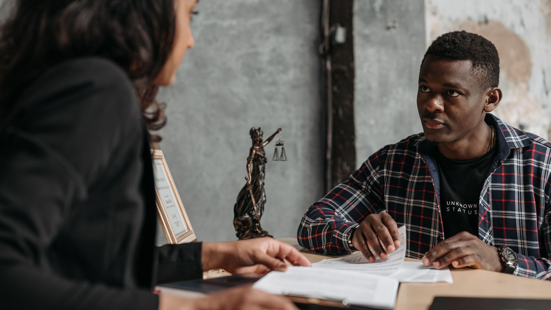 Business meeting between a lawyer and client in a professional office setting.