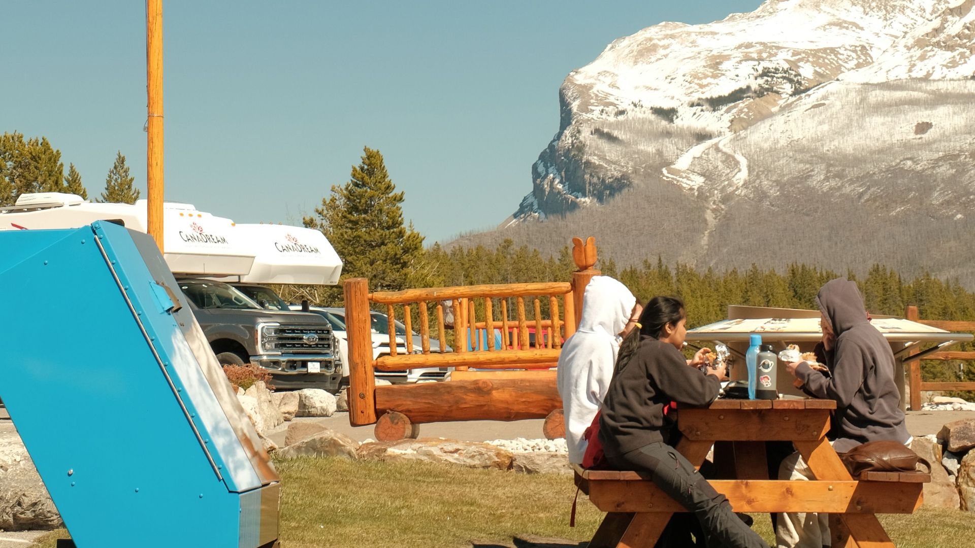Friends enjoying a picnic with mountain views in Banff, Alberta, Canada.
