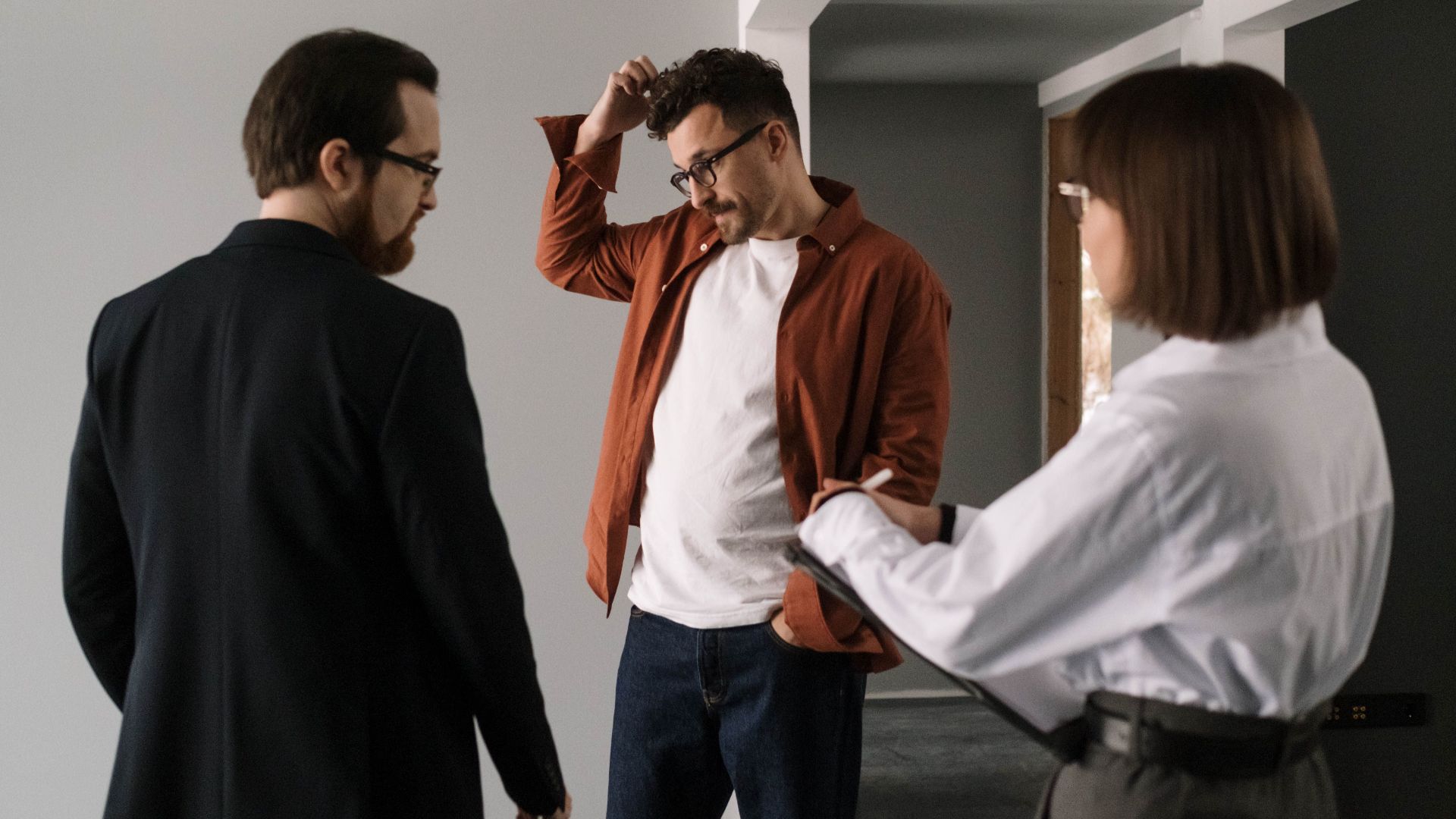 Three professionals discussing interior design project in a contemporary office setting.