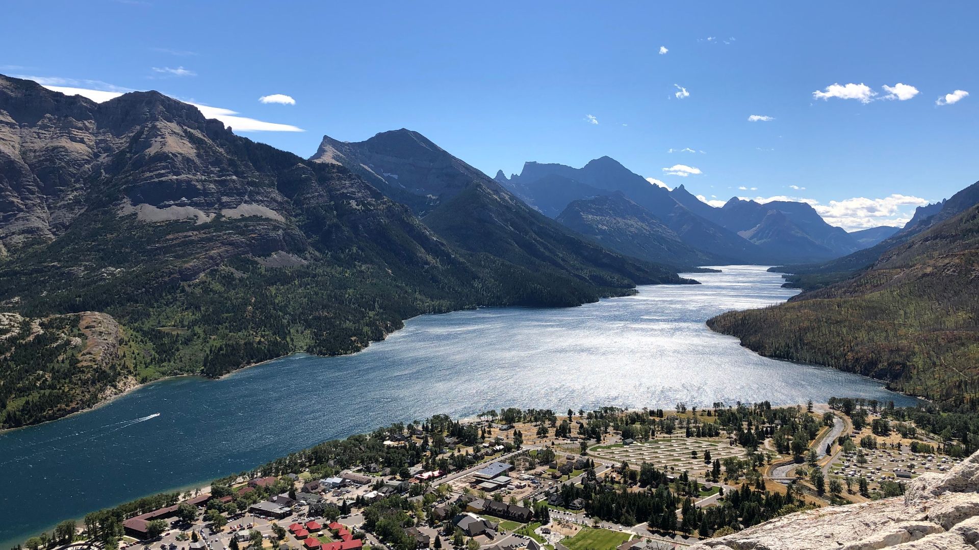Scenic overlook of Waterton Lakes surrounded by majestic mountains and lush greenery.