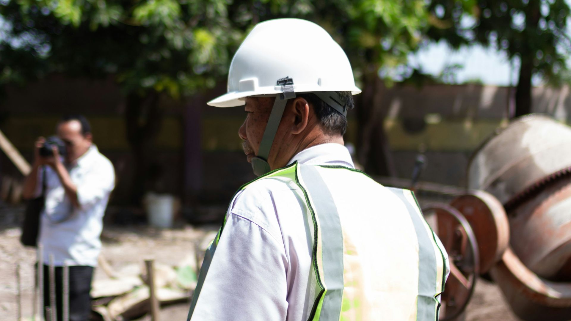 Construction worker wearing a hard hat and vest at site