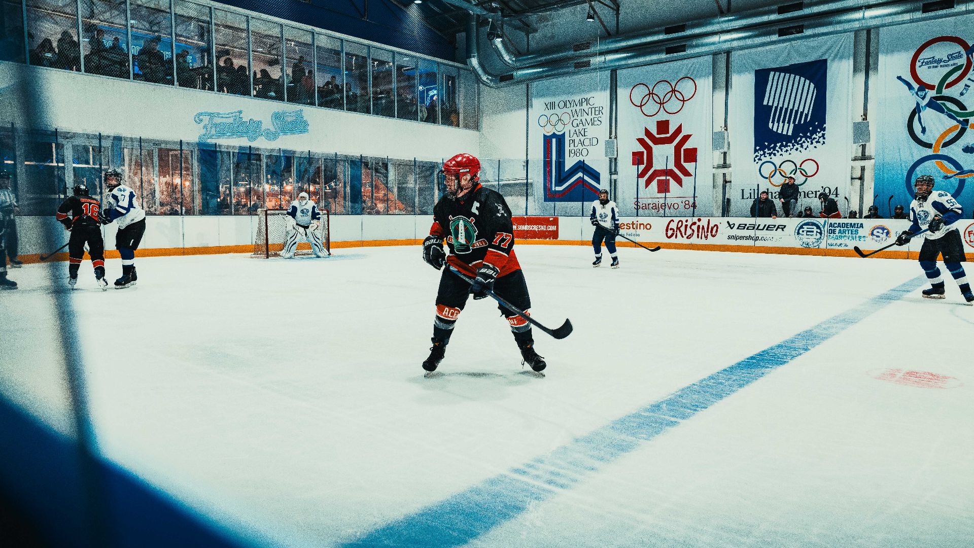 Action-filled scene of ice hockey match at an indoor arena, showcasing players in competition.