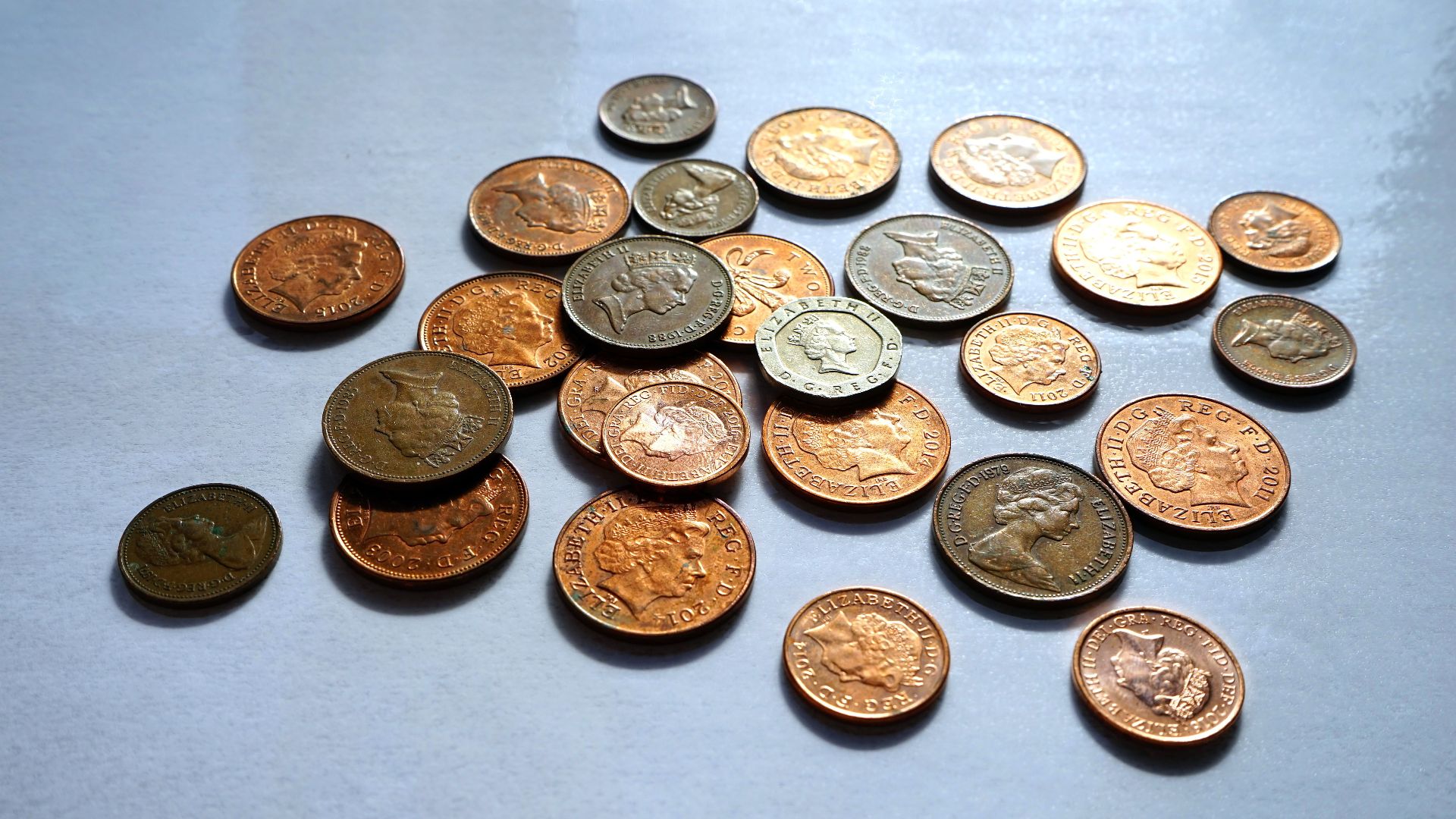 Pile of assorted coins on a white background, ideal for finance themes.