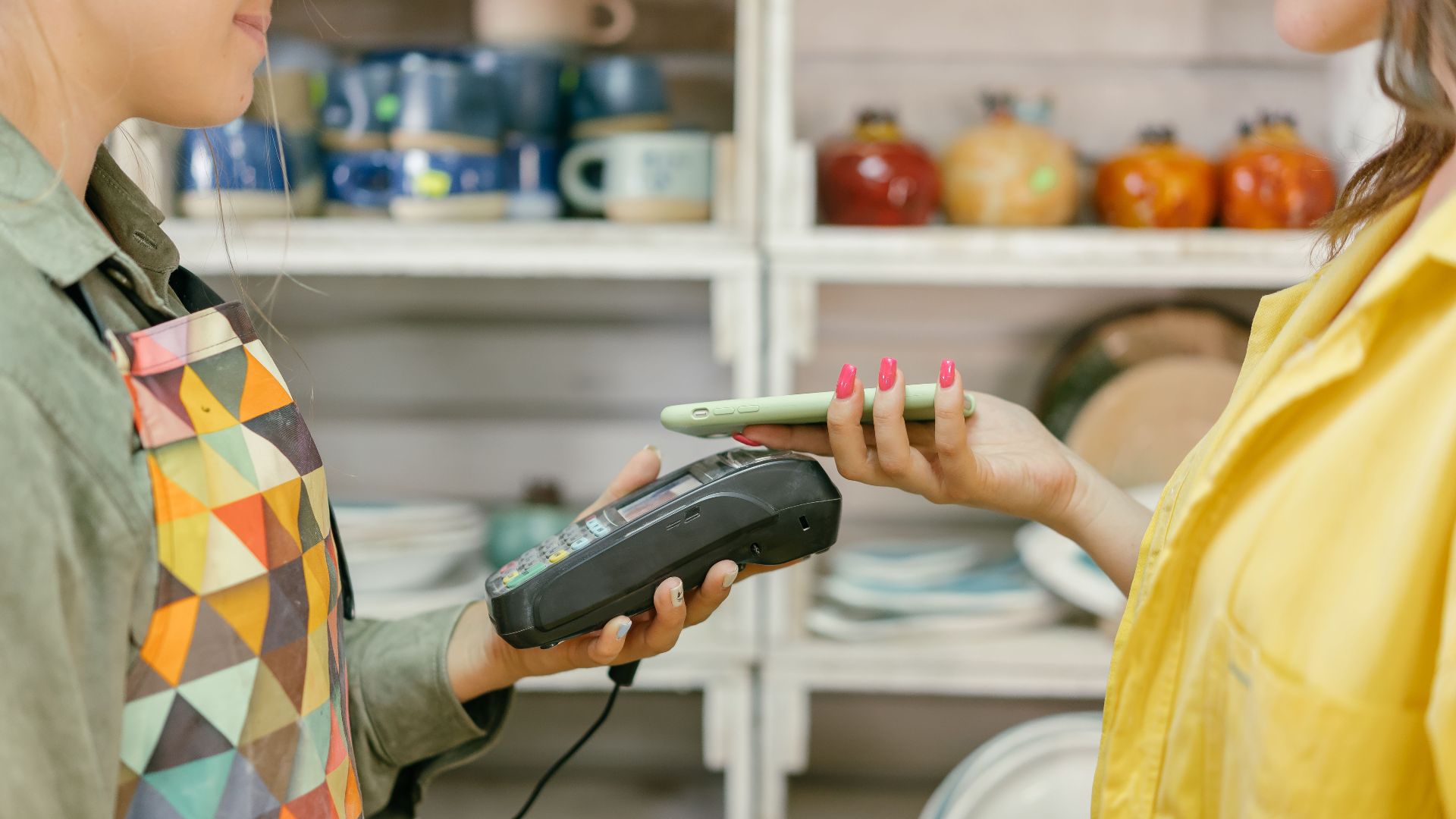 A customer makes a cashless payment using a smartphone in a retail store. Modern technology meets convenience.