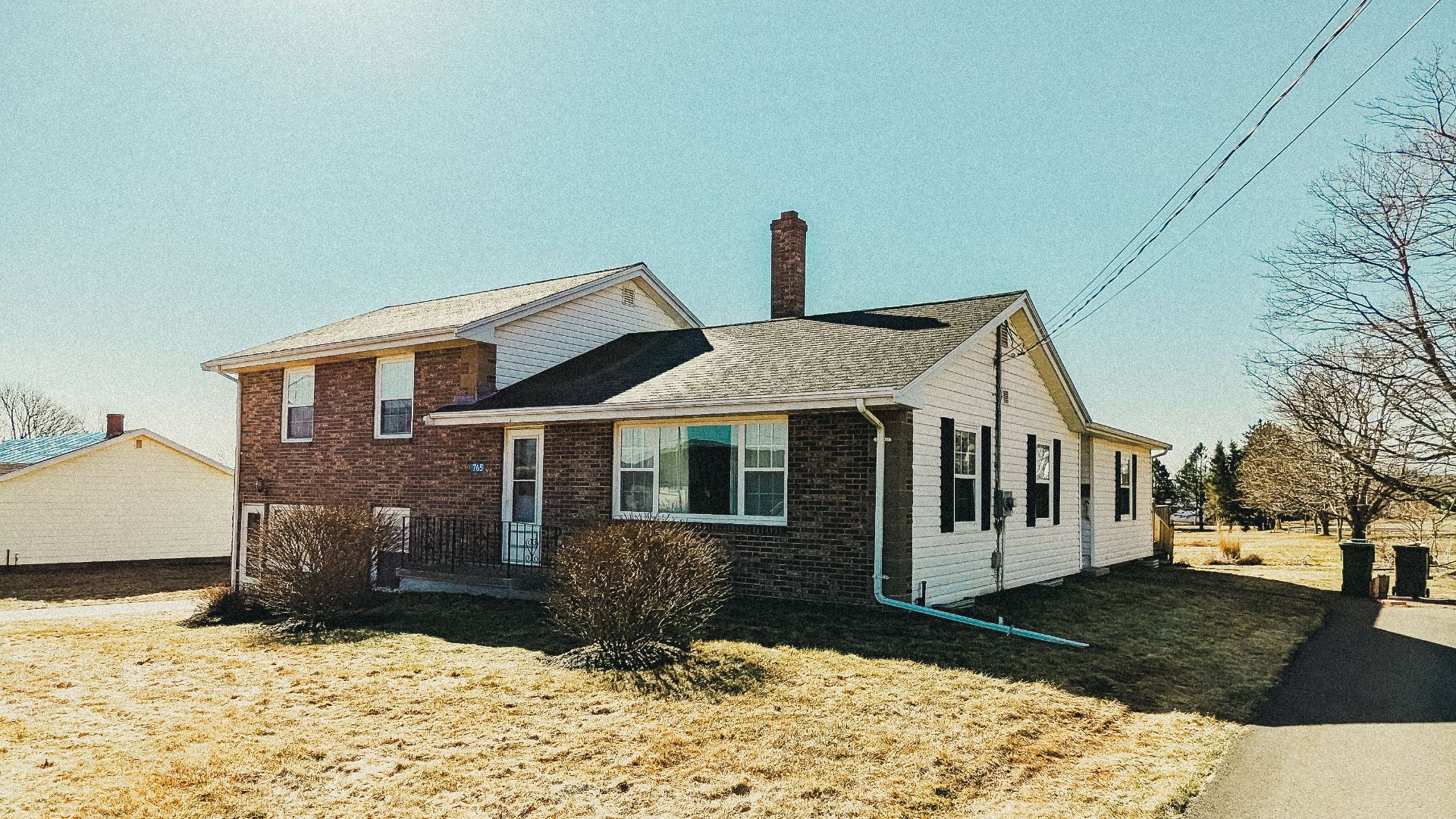 A traditional home in rural Cornwall, PEI, featuring expansive fields and blue skies in summer.