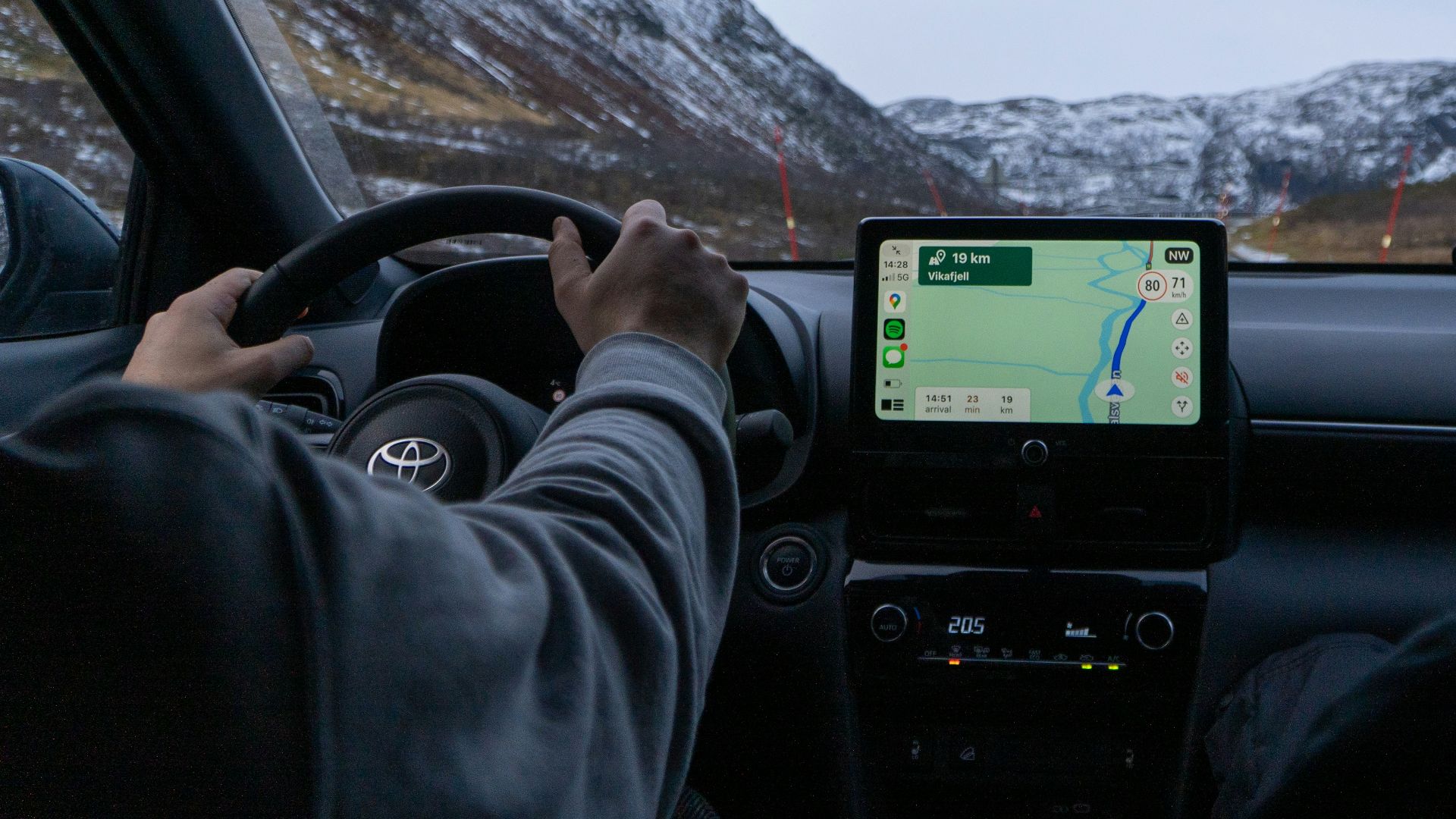 A man driving a car with a gps device in his hand