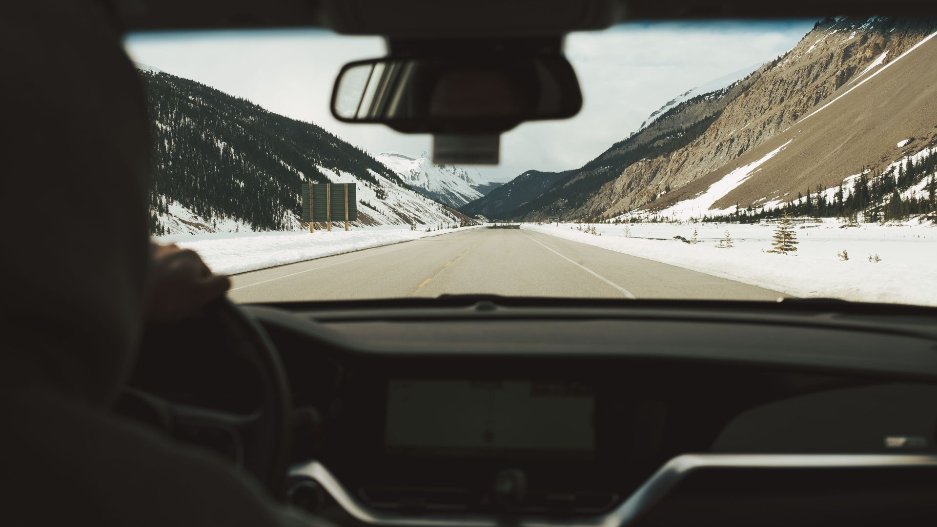 Experience a scenic winter drive through the snow-covered mountains of Banff National Park, Alberta.