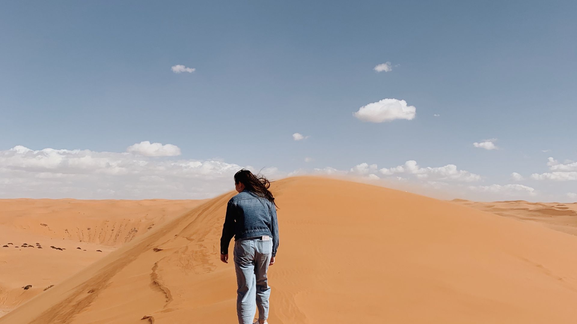 Hiking through the dunes of Saudi Arabia on a windy day.