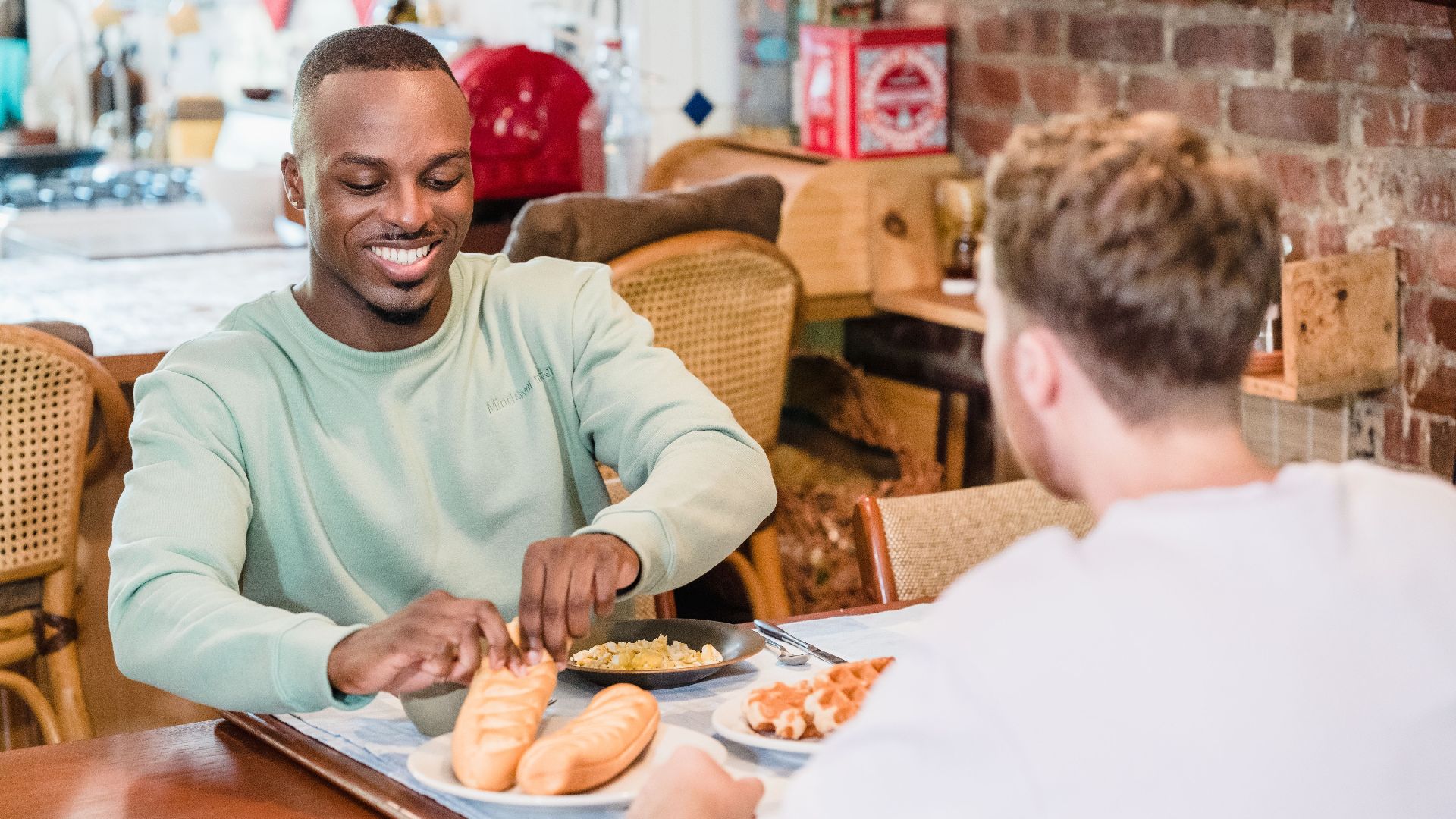 Cheerful couple sharing a meal in the kitchen, embracing a cozy morning ambiance.