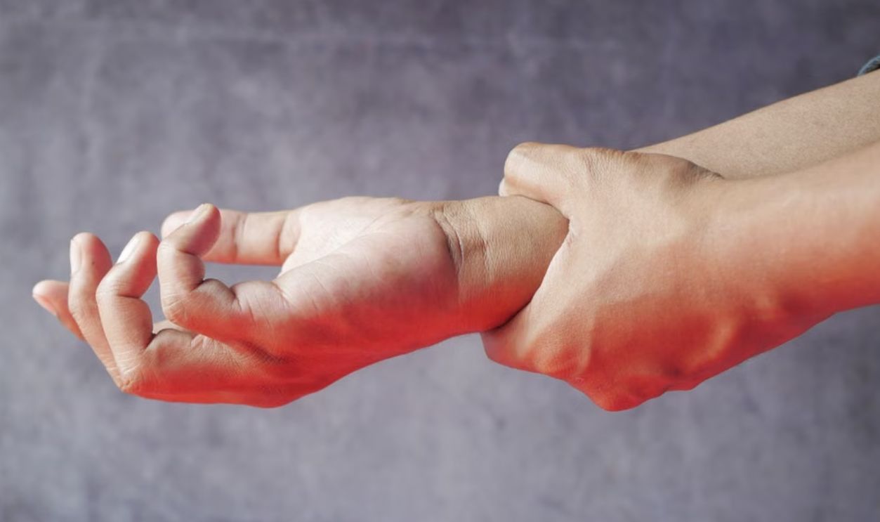 Close-up of hands, one grasping the other, symbolizing pain or discomfort