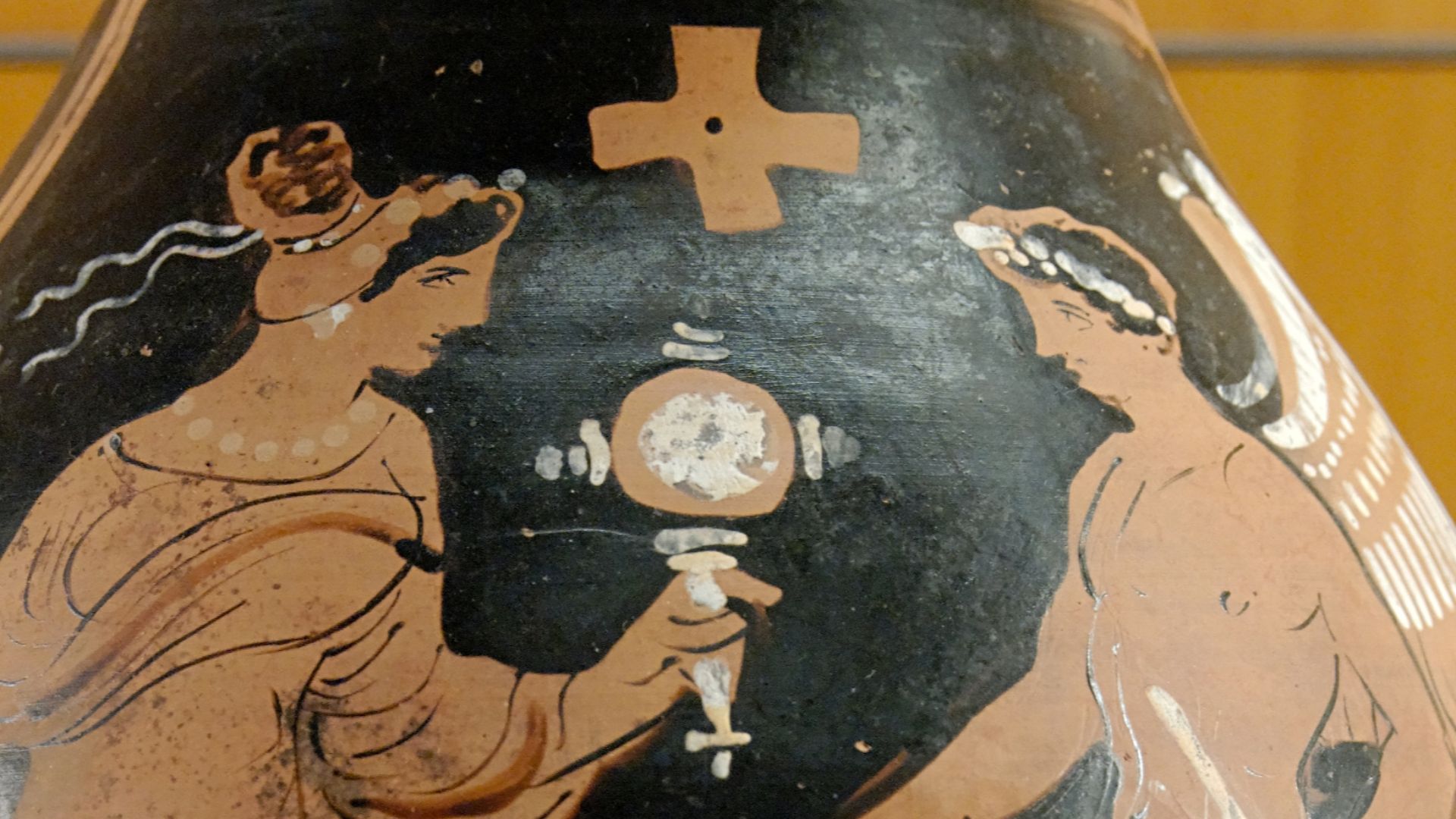 Woman holding a mirror and a tambourine facing a winged genie with a ribbon and a branch with leaves. Red-figure oinochoe, ca. 320 BC. From Magnia Graecia.