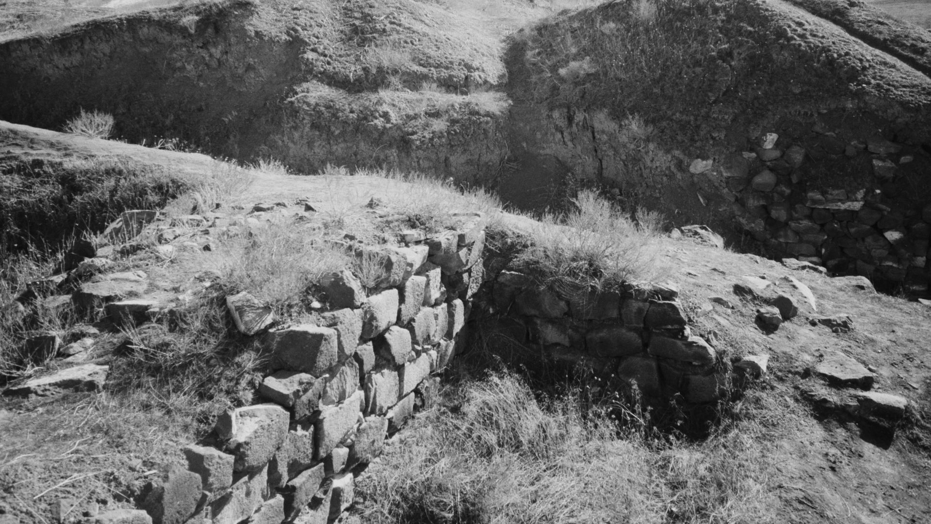 a rocky hillside with a stone wall