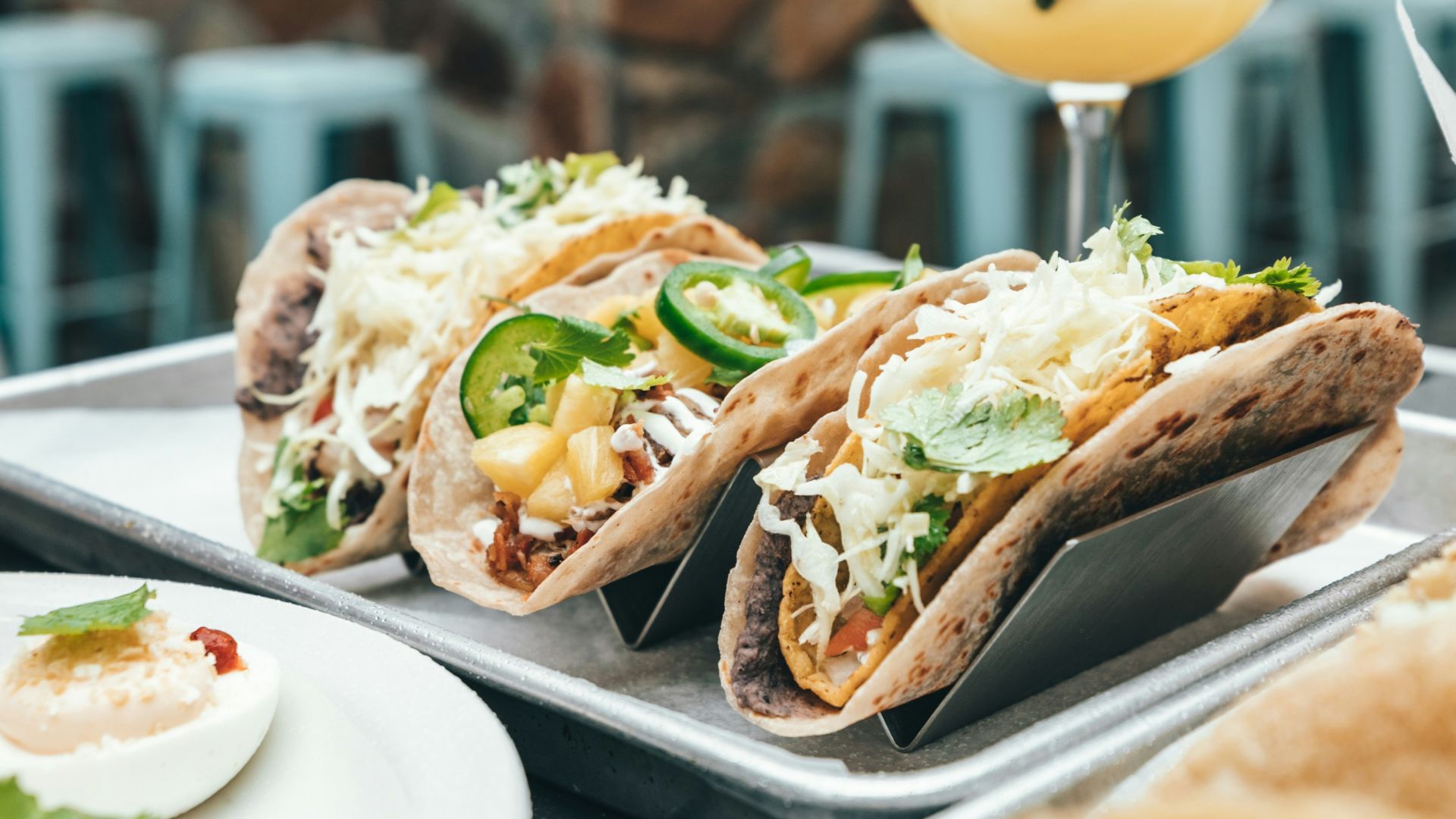 three tacos on play beside juice glass