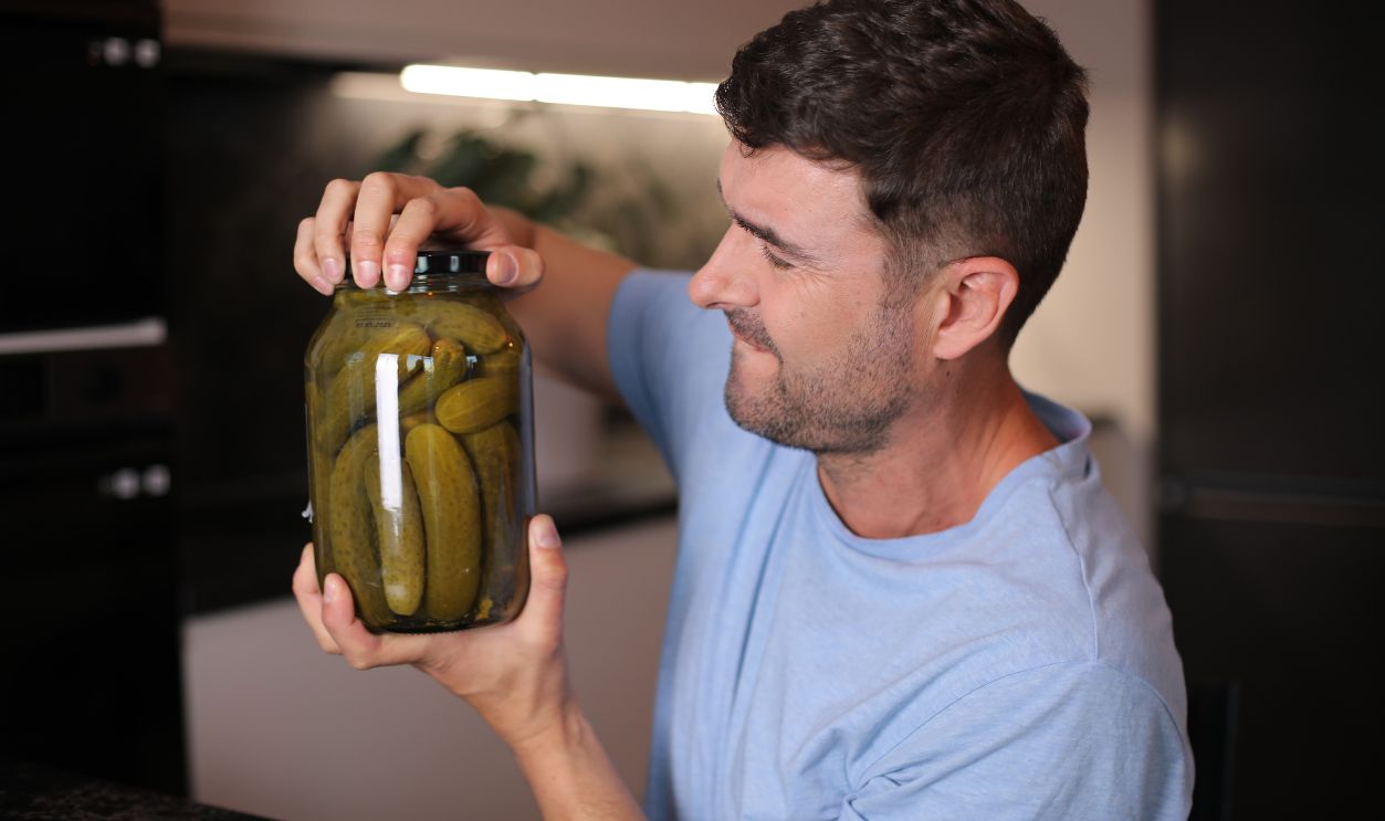 Man trying to open a pickles jar
