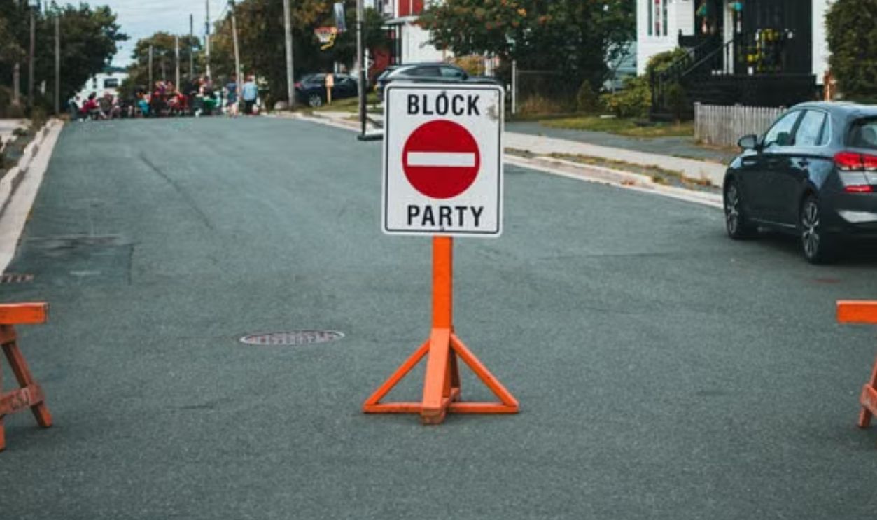 Street closed with sign for a neighborhood block party event outdoors