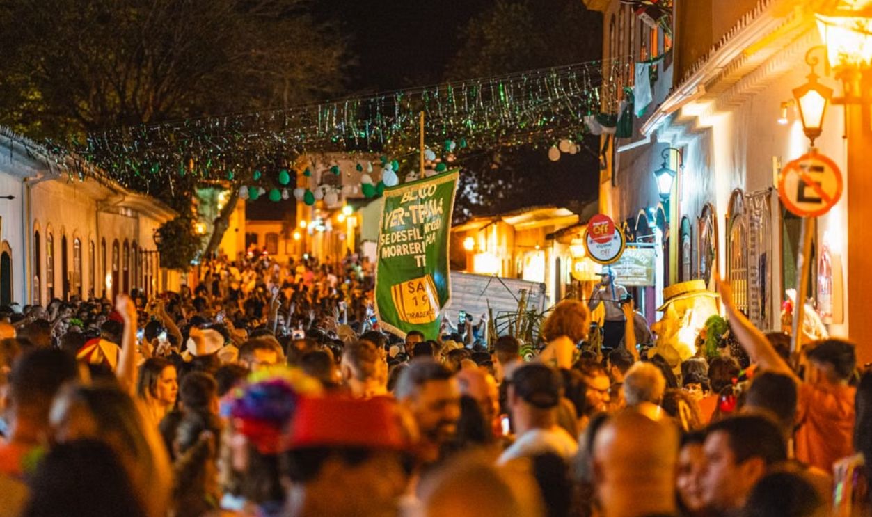 A bustling festival street scene in Tiradentes, Brazil, filled with lights and joyful revelers