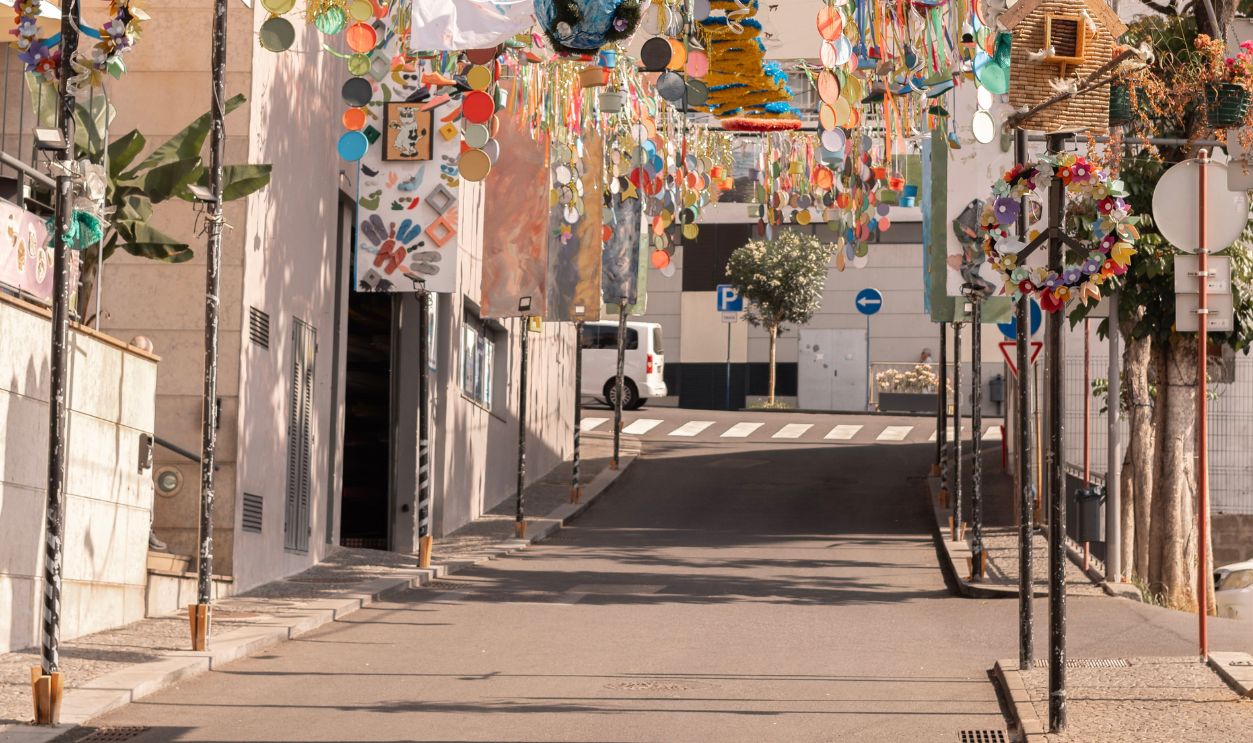 Stunning street adorned with vibrant hanging art and decorations in a sunny urban environment