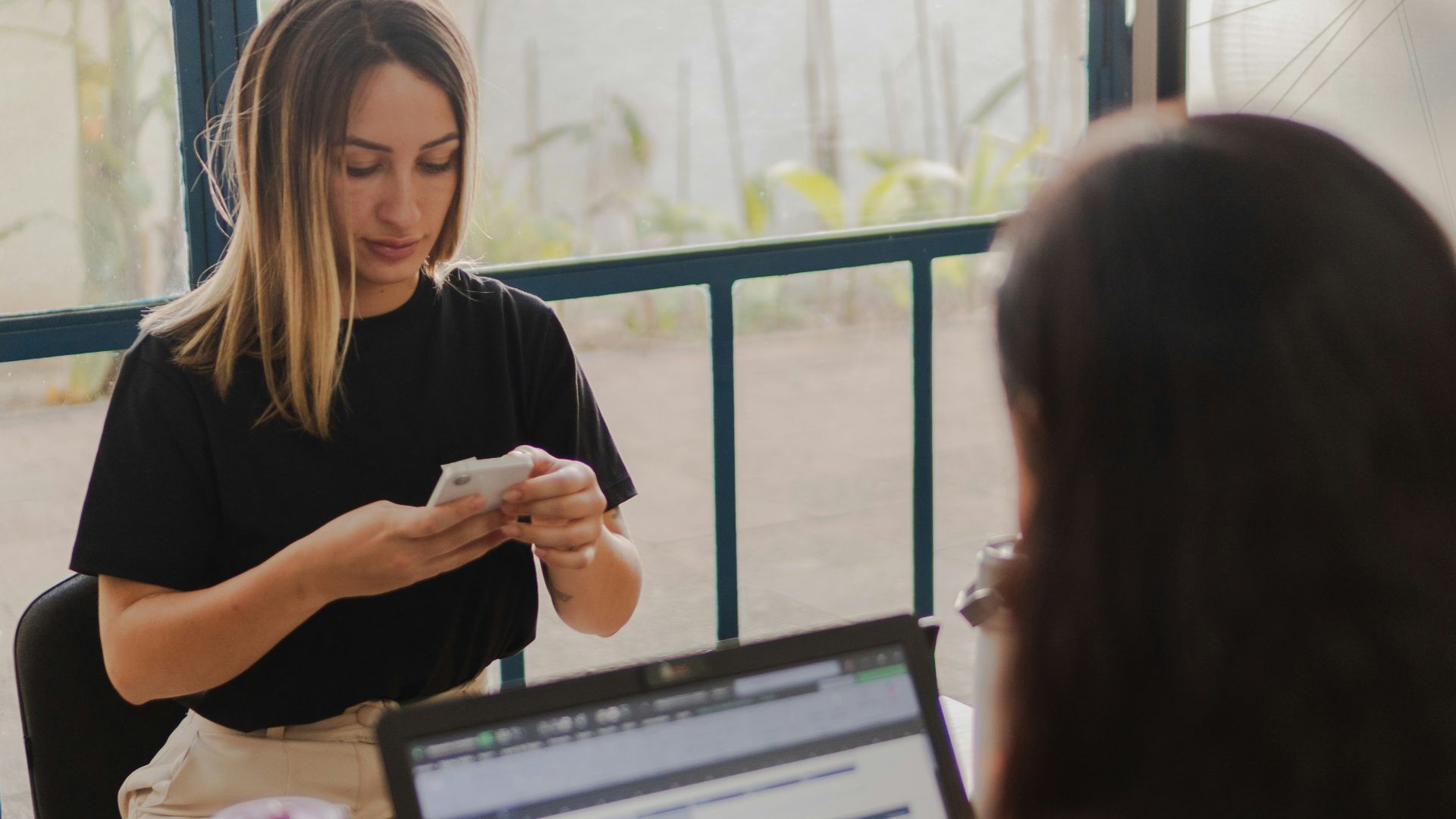 Two women working at a desk with a laptop