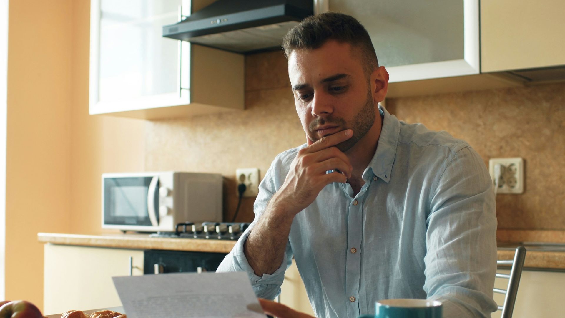 Man reading a document in a kitchen