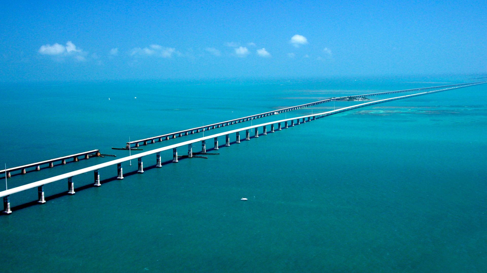 Seeming to converge in the distance, the Seven-mile Bridge on the Florida Keys Scenic Highway west of Marathon, FL, runs parallel to the historic Flagler railroad bridge of the early 1900s with the Atlantic Ocean to the South and the Gulf of Mexico to the