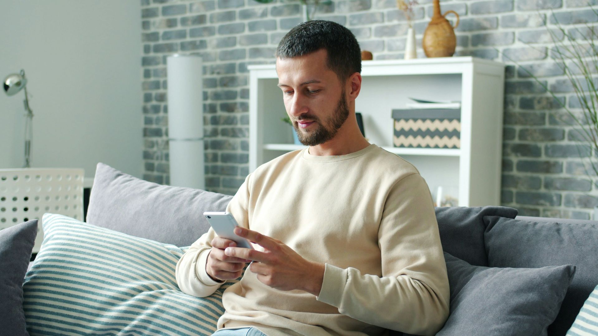 Man sitting on sofa using smartphone