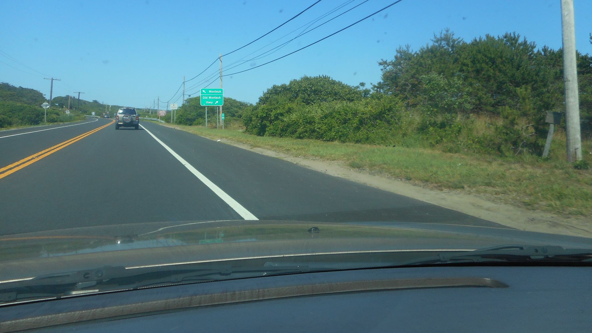 Directional sign along eastbound New York State Route 27 (Montauk Point State Parkway) in Napeague, New York, giving motorists the choice of continuing along NY 27 towards Downtown Montauk, and later Montauk Point, or veering to the right along Old Montau