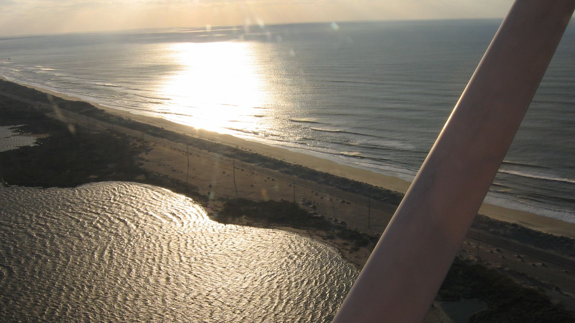 Scope and content:  The original finding aid described this photograph as:
Original Caption: This aerial view of the Sandy Bay Soundside access and walkway gilded by morning light shows how narrow this point of Hatteras Island is.
Location: Hatteras Islan