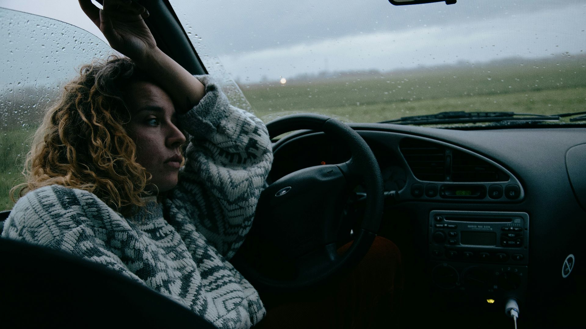 woman in black and white scarf driving car