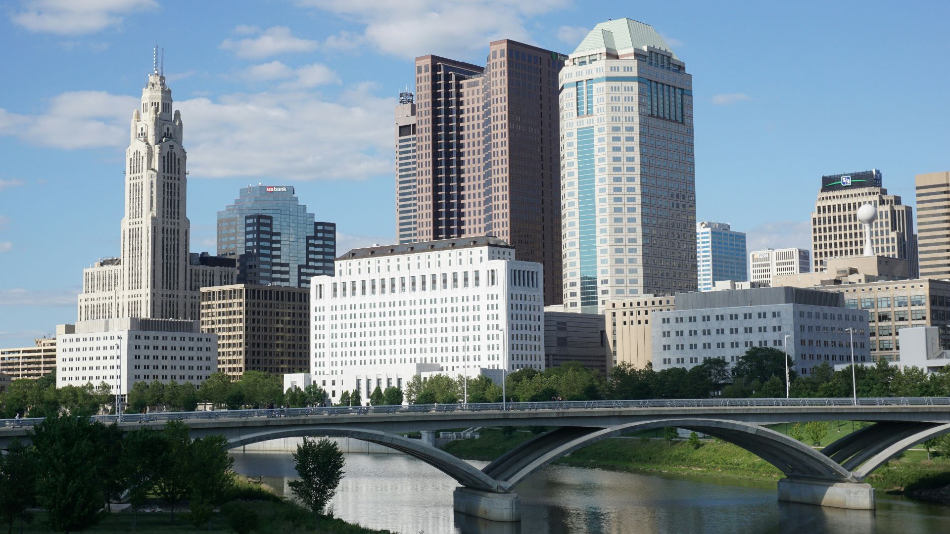 a bridge over a river with a city in the background
