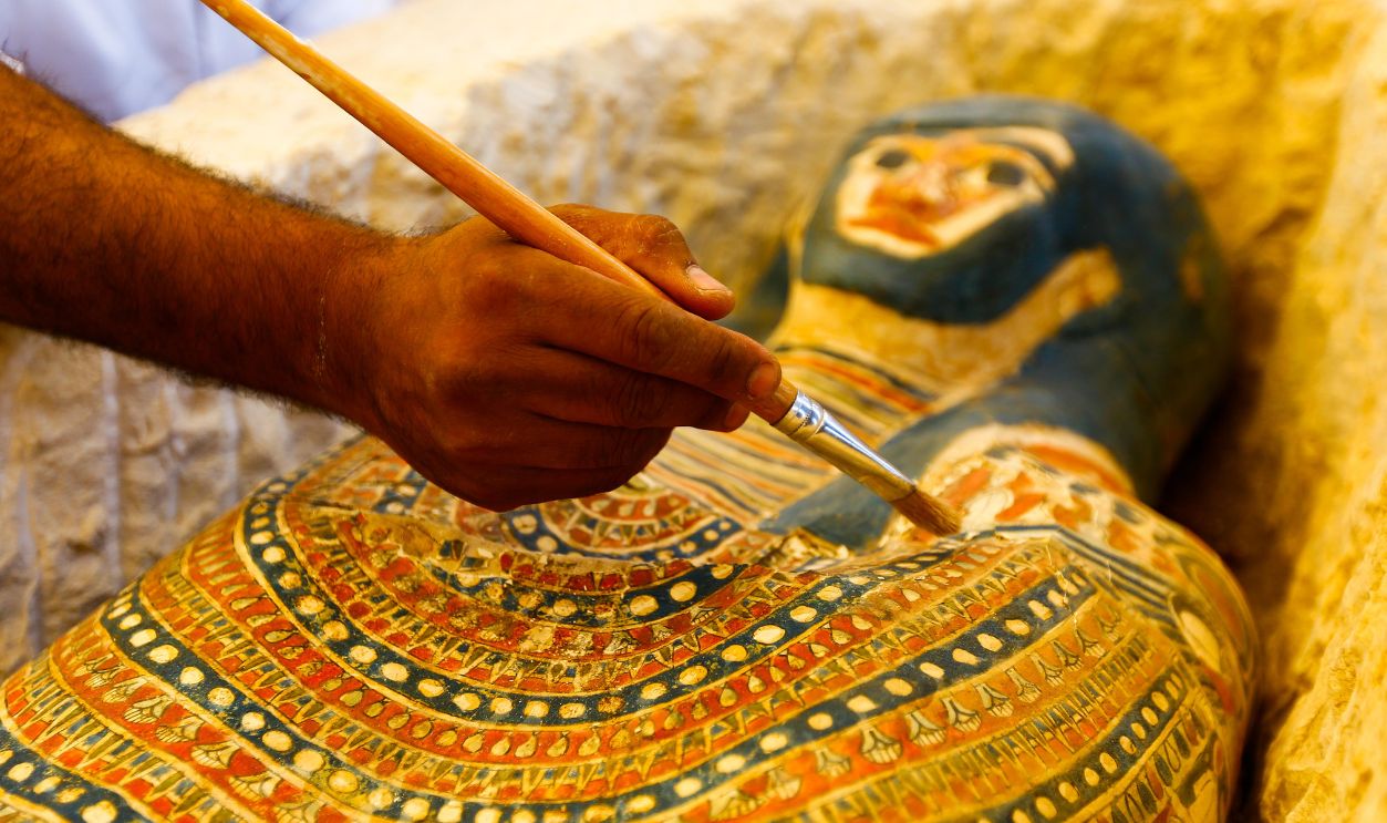 12 July 2019, Egypt, Dahshur: An Egyptian archaeological expert works on a newly discovered Pharaonic sarcophagi, which according to Egyptian authorities dates bake to the Middle Kingdom of Egypt, discovered near the Bent Pyramid of Sneferu. 
