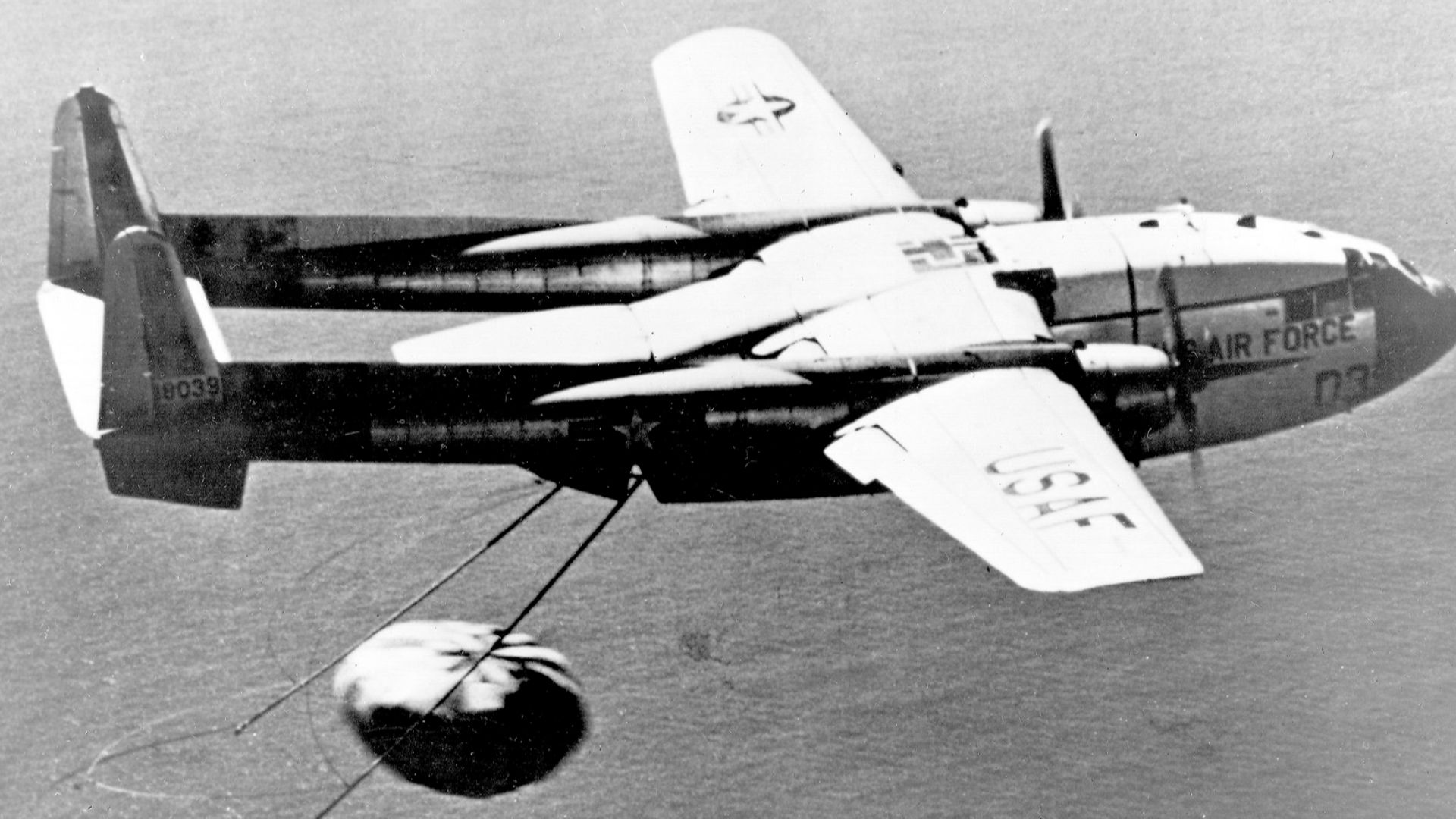 1960's -- U.S. Air Force C-119J recovers a CORONA Capsule returned from Space. The C-119J was specially modified for the mid-air retrieval of space capsules re-entering the atmosphere from orbit. On August 19, 1960, this aircraft made the world's first mi