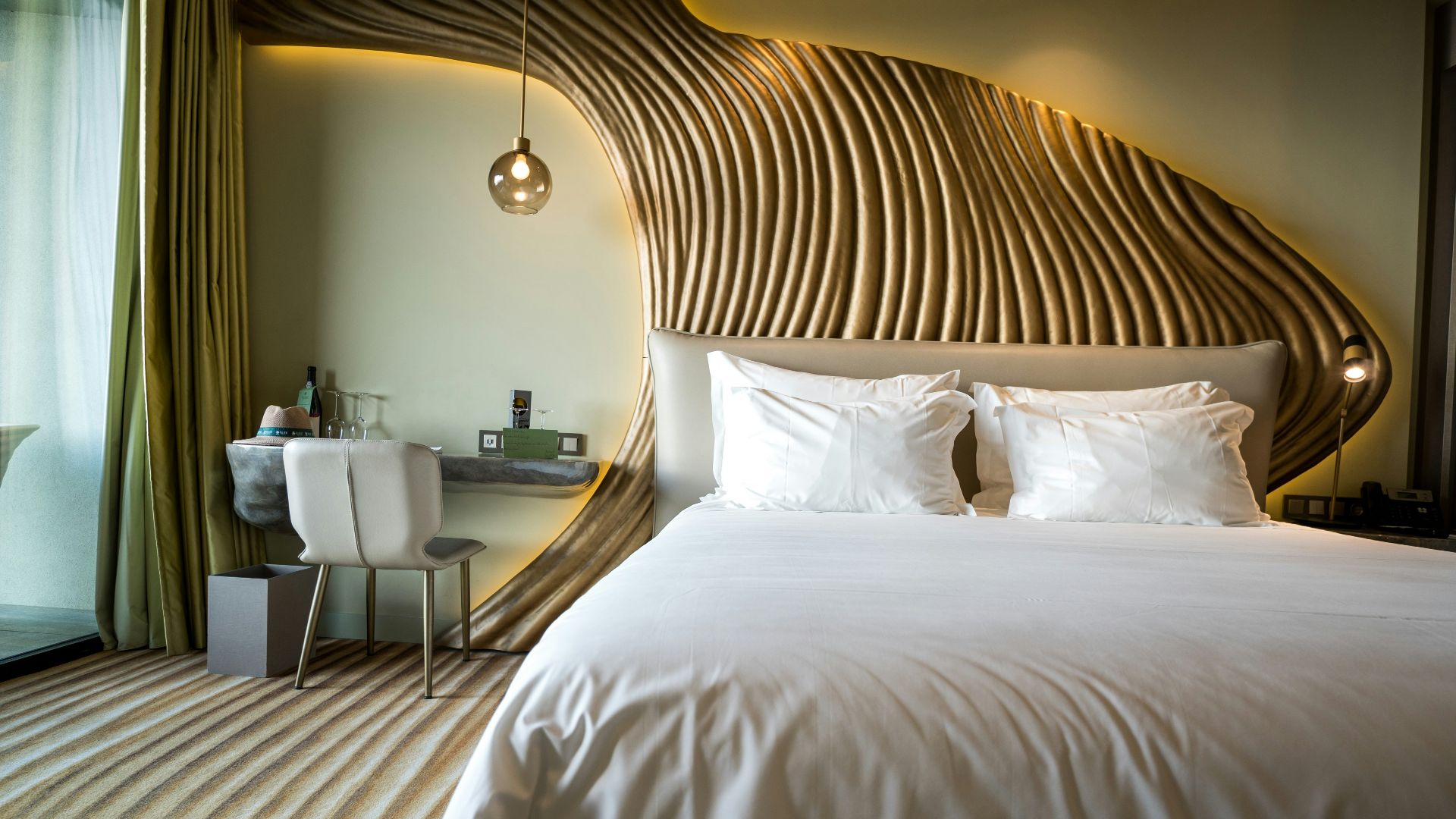 A bedroom with a white bed and a wooden headboard